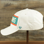 The wearer's left on the Throwback Miami Dolphins Striped Wordmark Legacy Dolphins Side Patch Crossroad Dad Hat | Bone Dad Hat
