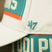The 47 Brand Logo on the Throwback Miami Dolphins Striped Wordmark Legacy Dolphins Side Patch Crossroad Dad Hat | Bone Dad Hat
