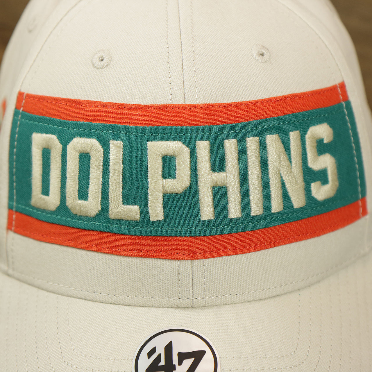 The Dolphins Wordmark on the Throwback Miami Dolphins Striped Wordmark Legacy Dolphins Side Patch Crossroad Dad Hat | Bone Dad Hat