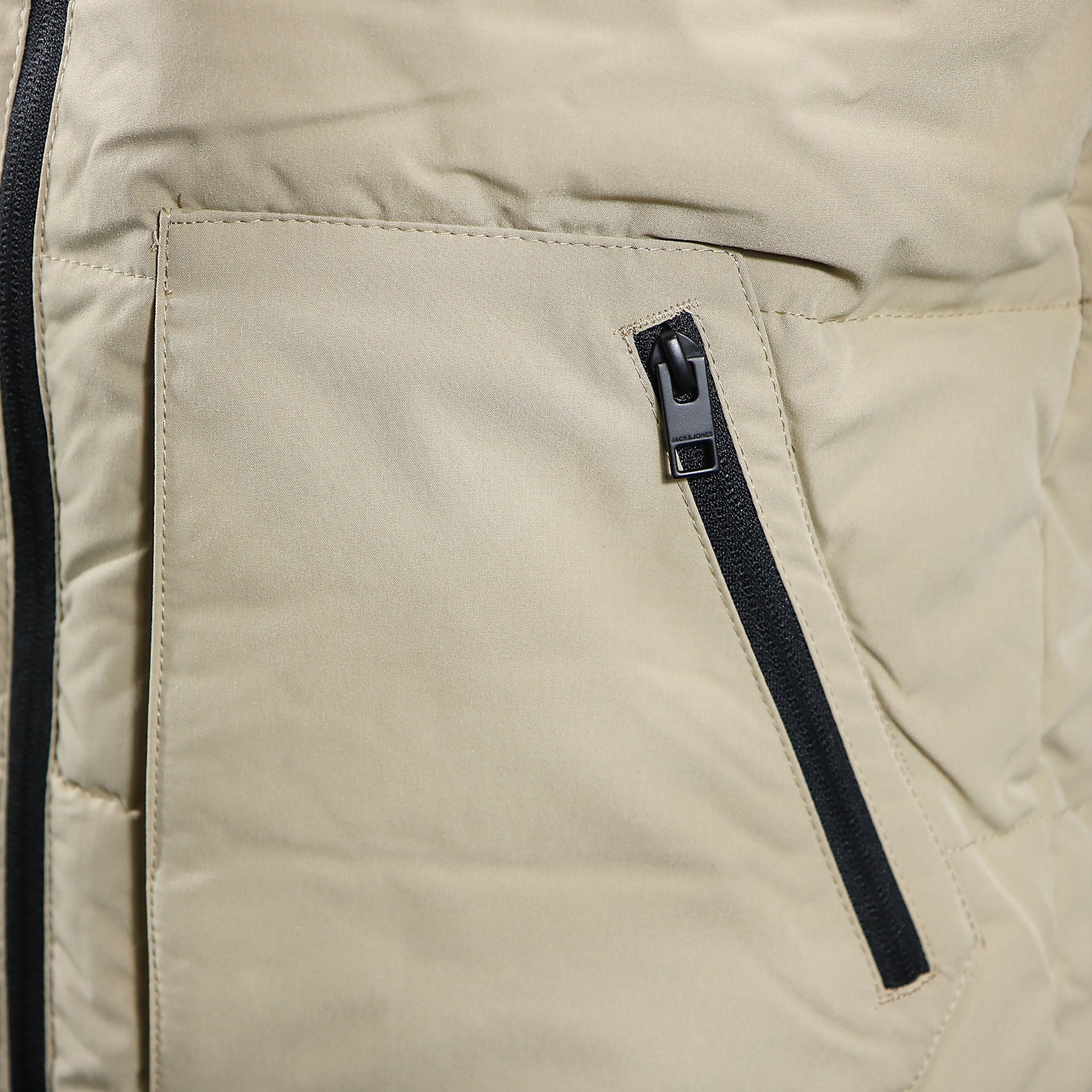 The waist pocket on the Jack And Jones Dune Puffer Jacket With Hidden Pocket | Black and Tan Puffer Jacket