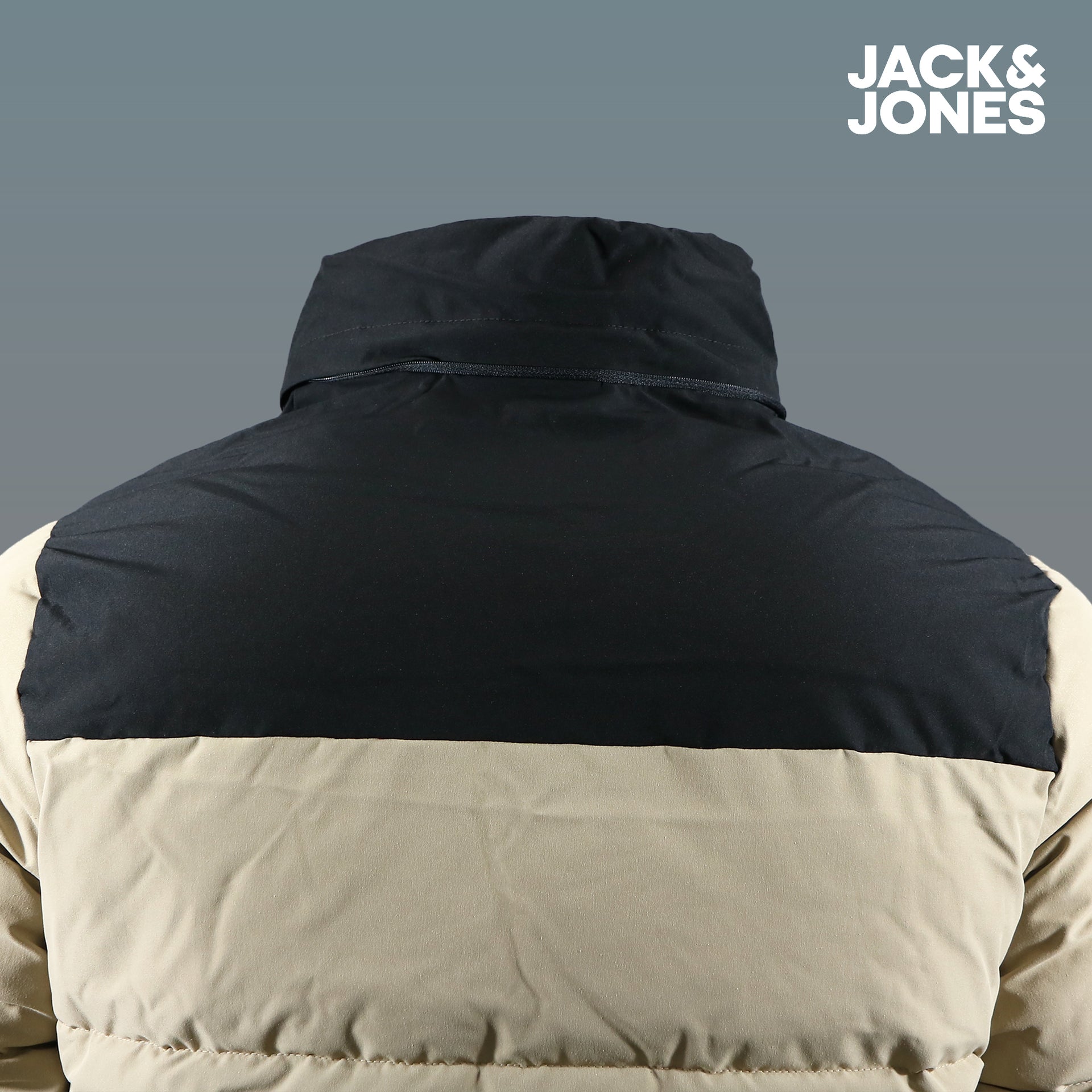 The backside of the Jack And Jones Dune Puffer Jacket With Hidden Pocket | Black and Tan Puffer Jacket without the hood