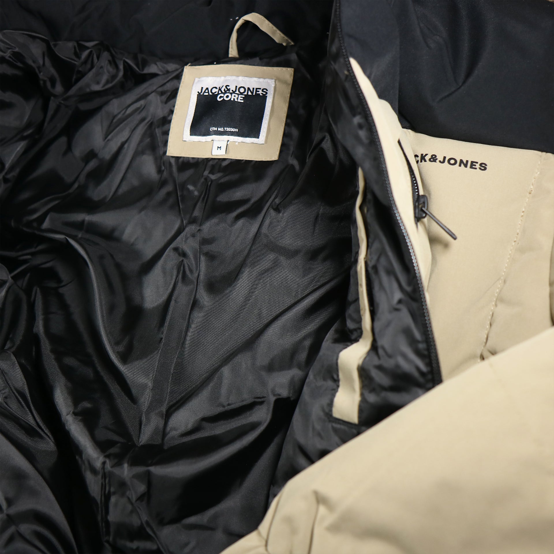 The inside of the Jack And Jones Dune Puffer Jacket With Hidden Pocket | Black and Tan Puffer Jacket