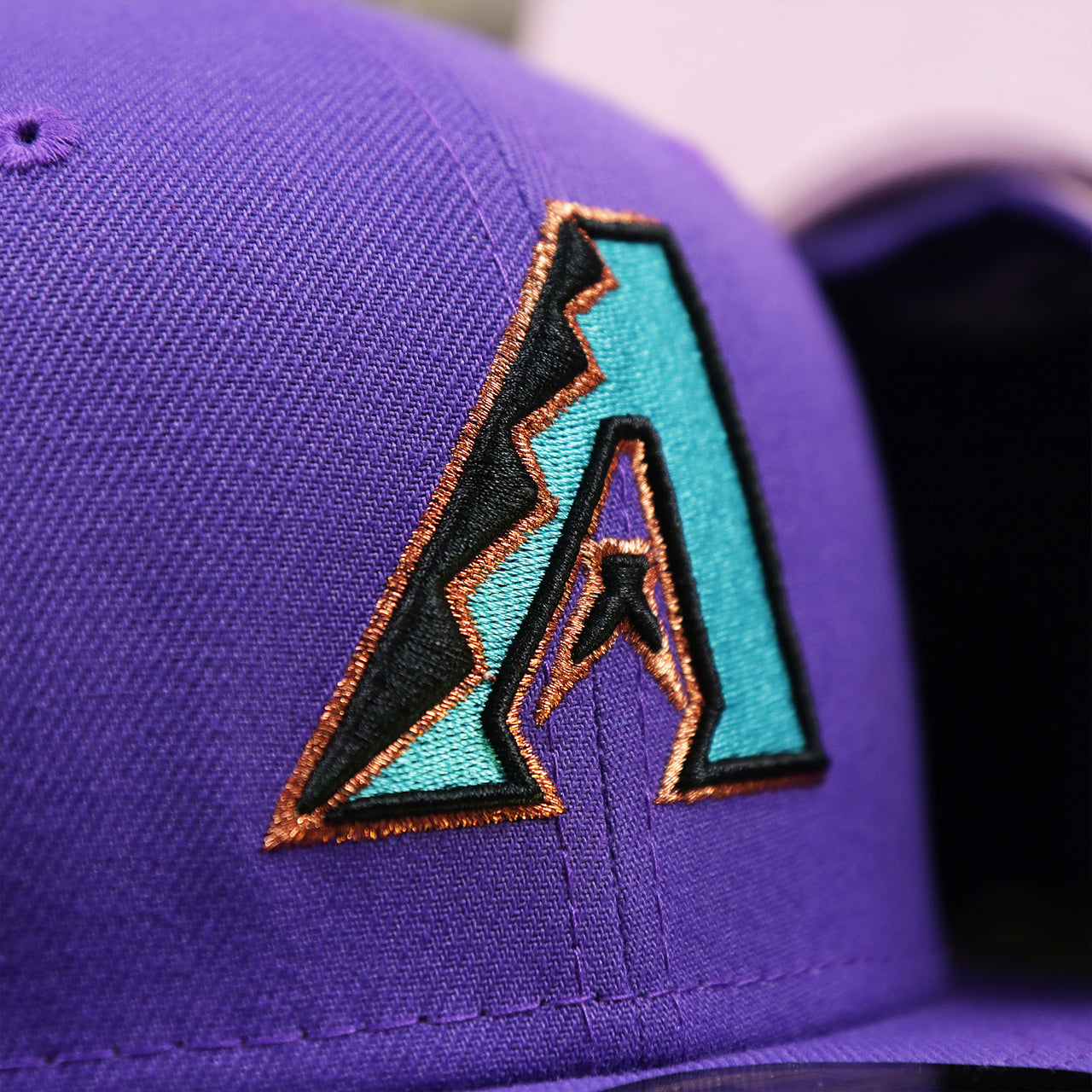 The Diamondbacks Logo on the Cooperstown Arizona Diamondbacks Pop Sweat Pastel World Series Side Patch Fitted Cap With Pink Undervisor | Purple 59Fifty Cap