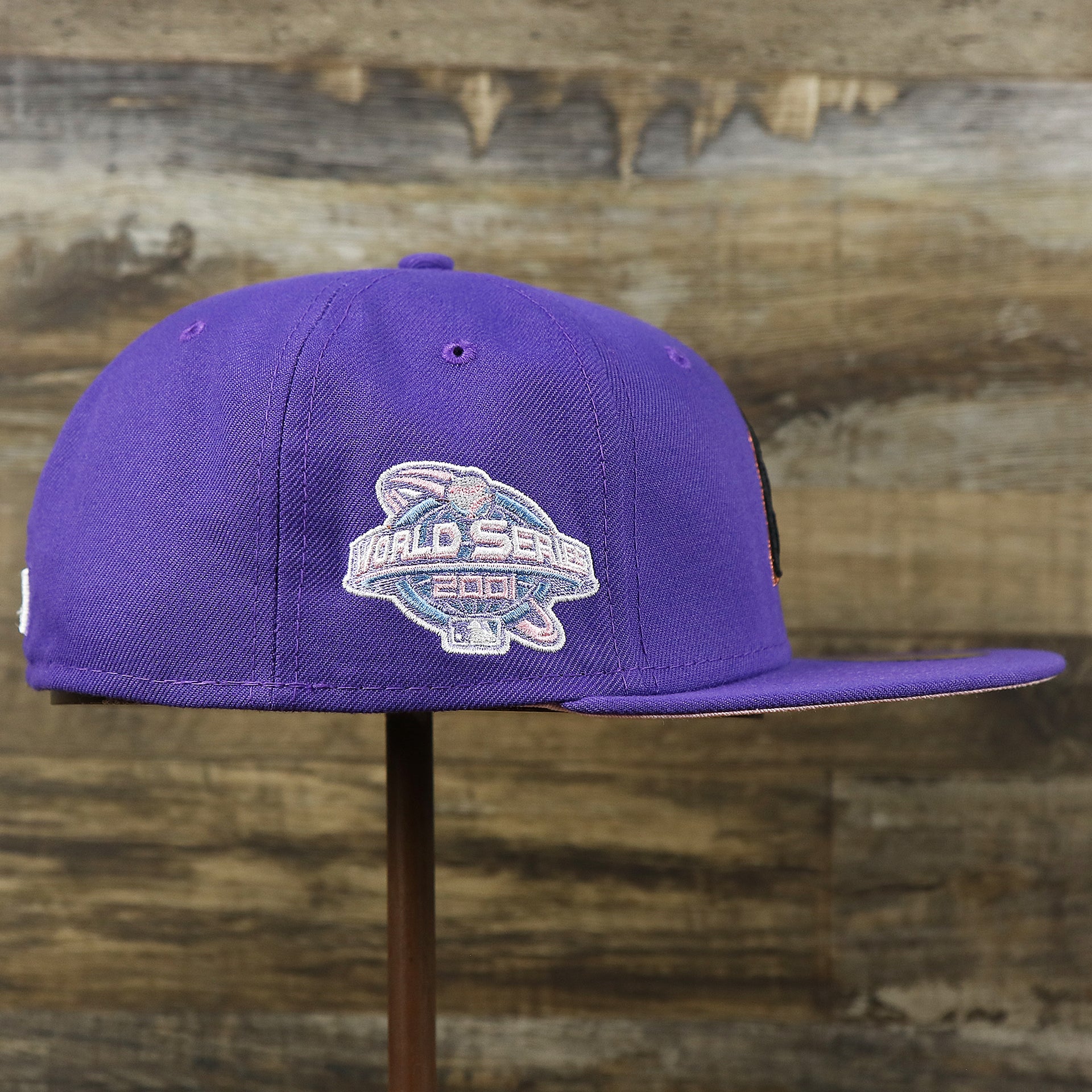 The wearer's right on the Cooperstown Arizona Diamondbacks Pop Sweat Pastel World Series Side Patch Fitted Cap With Pink Undervisor | Purple 59Fifty Cap
