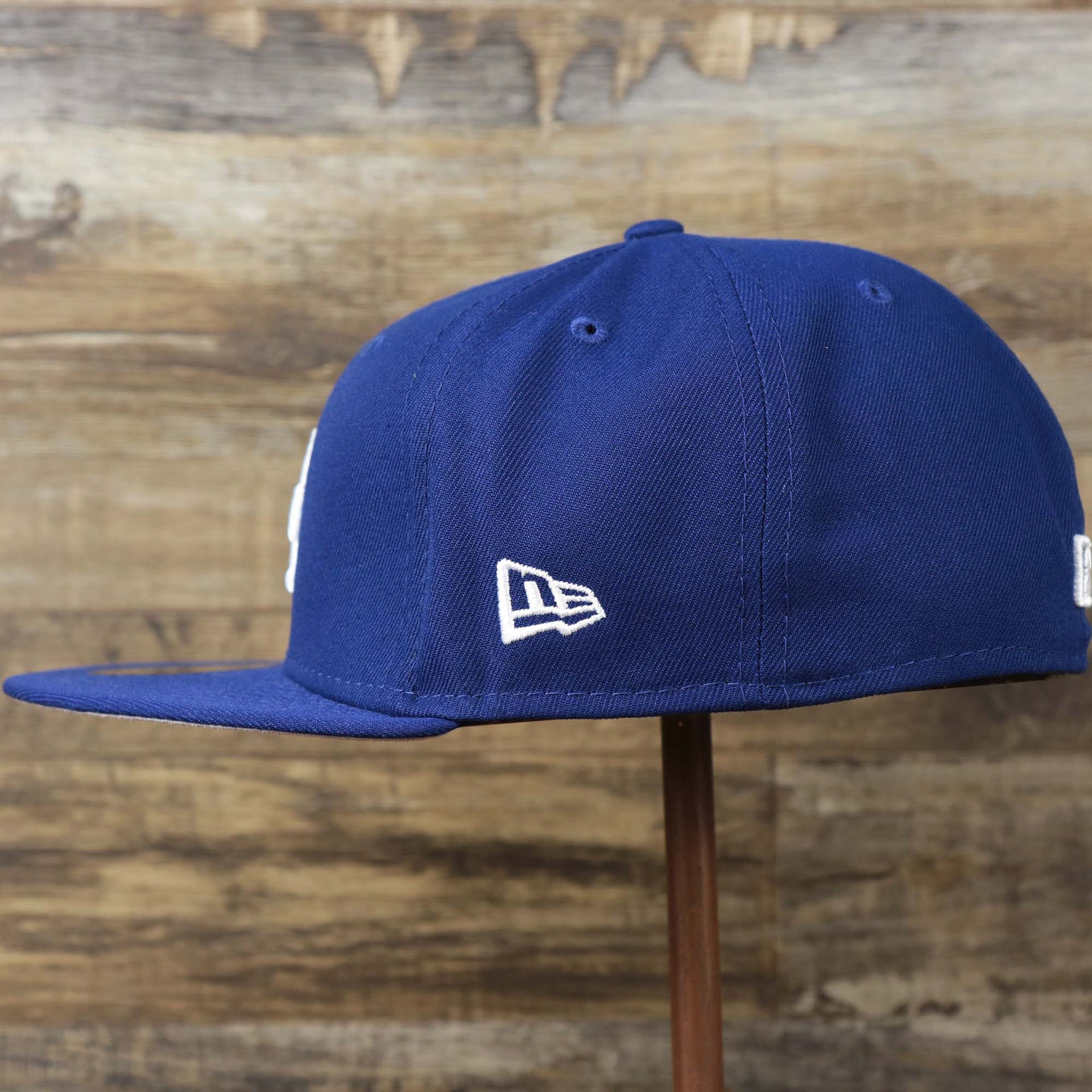 The wearer's left on the Los Angeles Dodgers Side Patch Fitted Gray Bottom 59Fifty Cap | Royal Blue 59Fifty