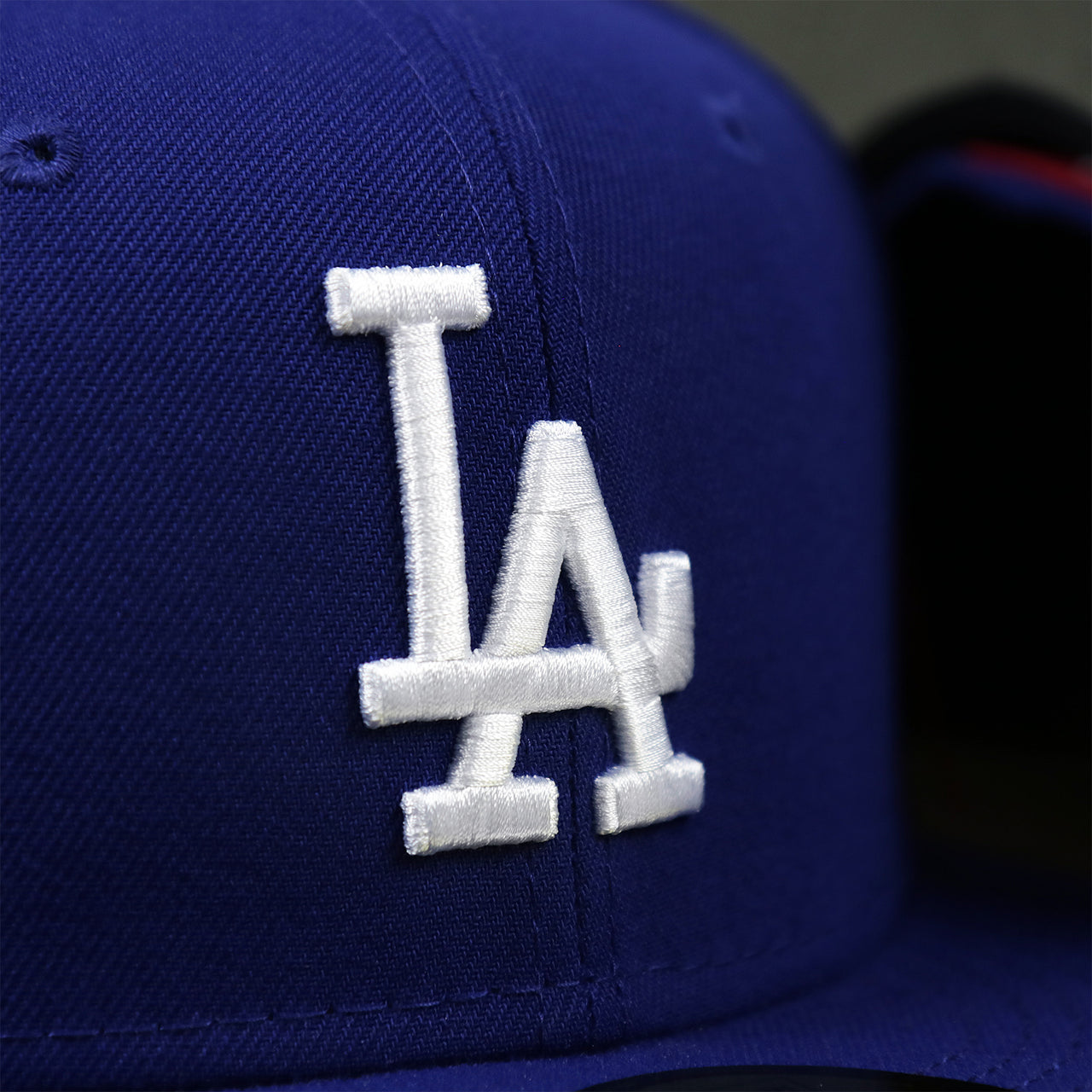 The Dodgers logo on the Los Angeles Dodgers Alpha Industries Side Patch Army Green Undervisor 59FIfty Fitted Cap With Hangtag | Royal Blue 59FIfty Cap