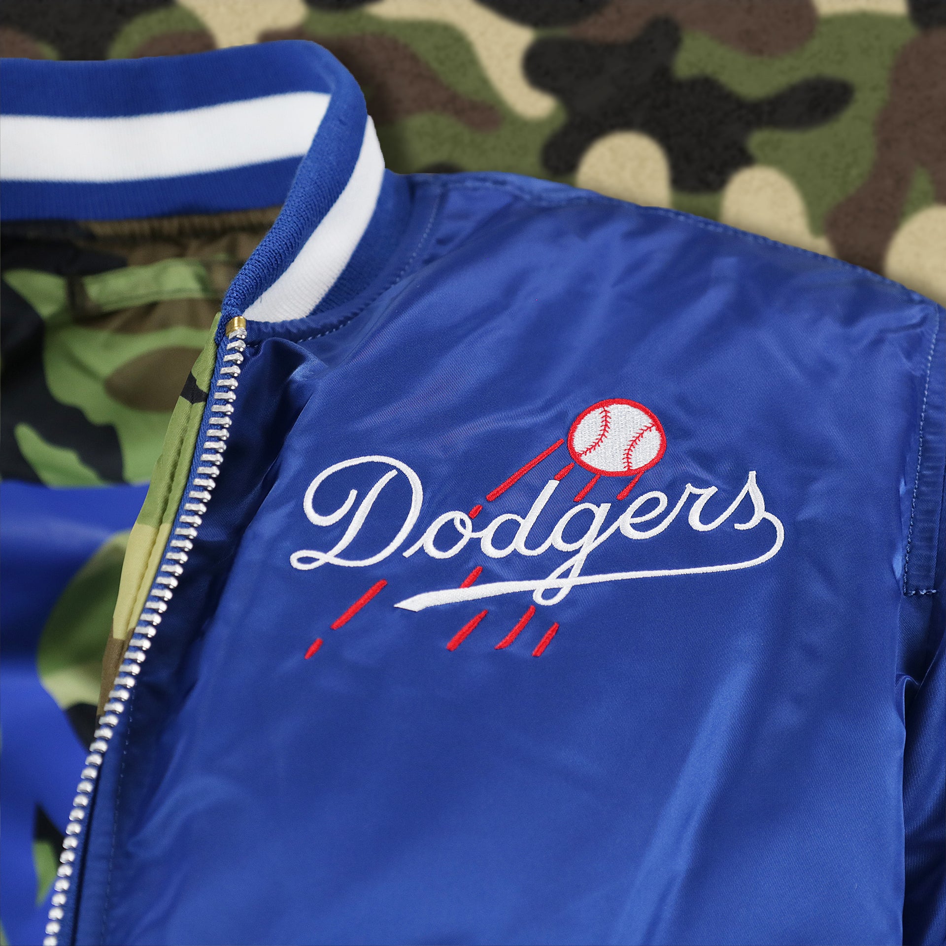 The Alternate Dodgers Logo on the Cooperstown Brooklyn Dodgers MLB Patch Alpha Industries Reversible Bomber Jacket With Camo Liner | Royal Blue Bomber Jacket