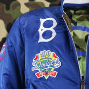 The Brooklyn Dodgers Logo and the 100th Anniversary Side Patch on the Cooperstown Brooklyn Dodgers MLB Patch Alpha Industries Reversible Bomber Jacket With Camo Liner | Royal Blue Bomber Jacket