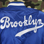 The Brooklyn Wordmark on the Cooperstown Brooklyn Dodgers MLB Patch Alpha Industries Reversible Bomber Jacket With Camo Liner | Royal Blue Bomber Jacket