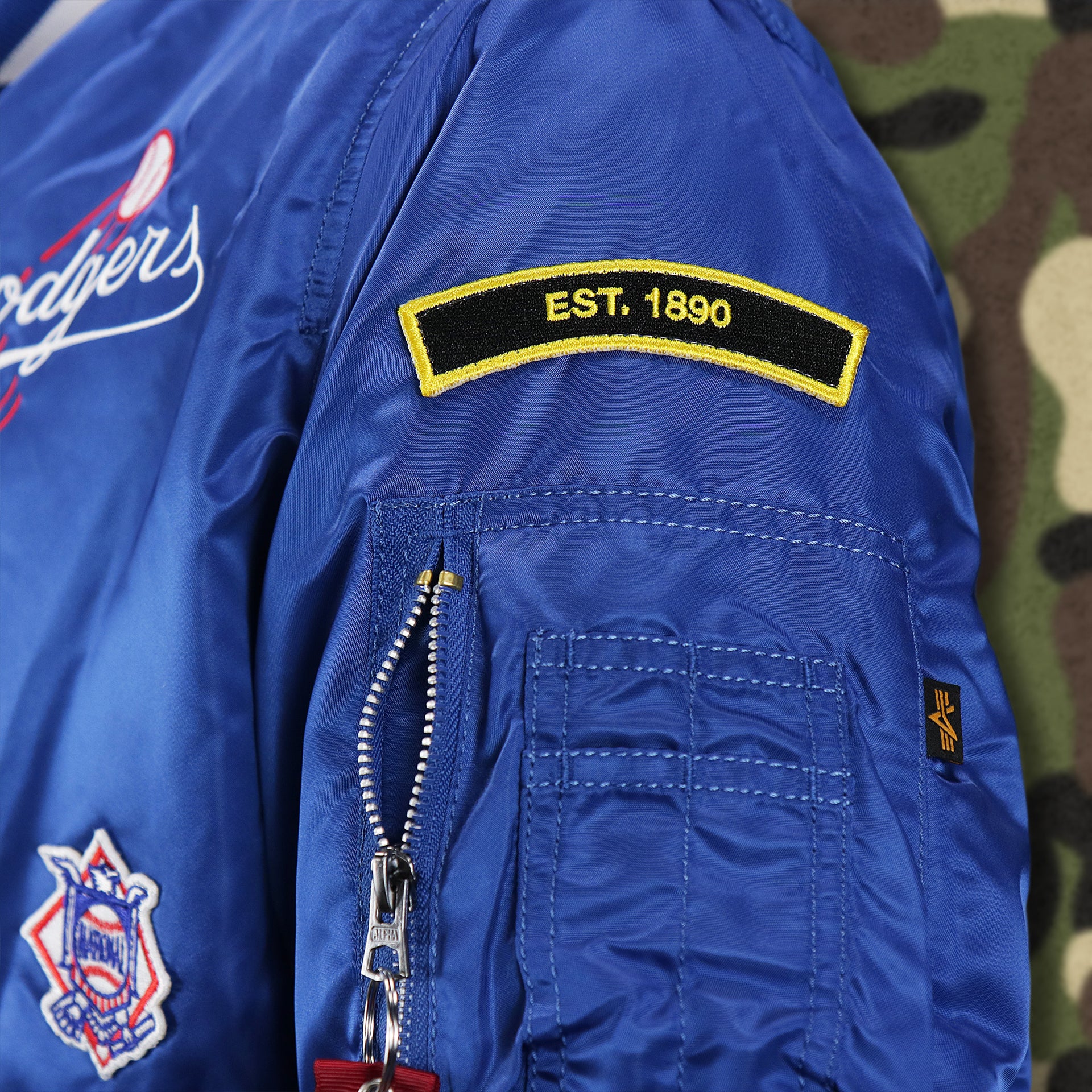 The Est. 1890 Side Patch on the Cooperstown Brooklyn Dodgers MLB Patch Alpha Industries Reversible Bomber Jacket With Camo Liner | Royal Blue Bomber Jacket