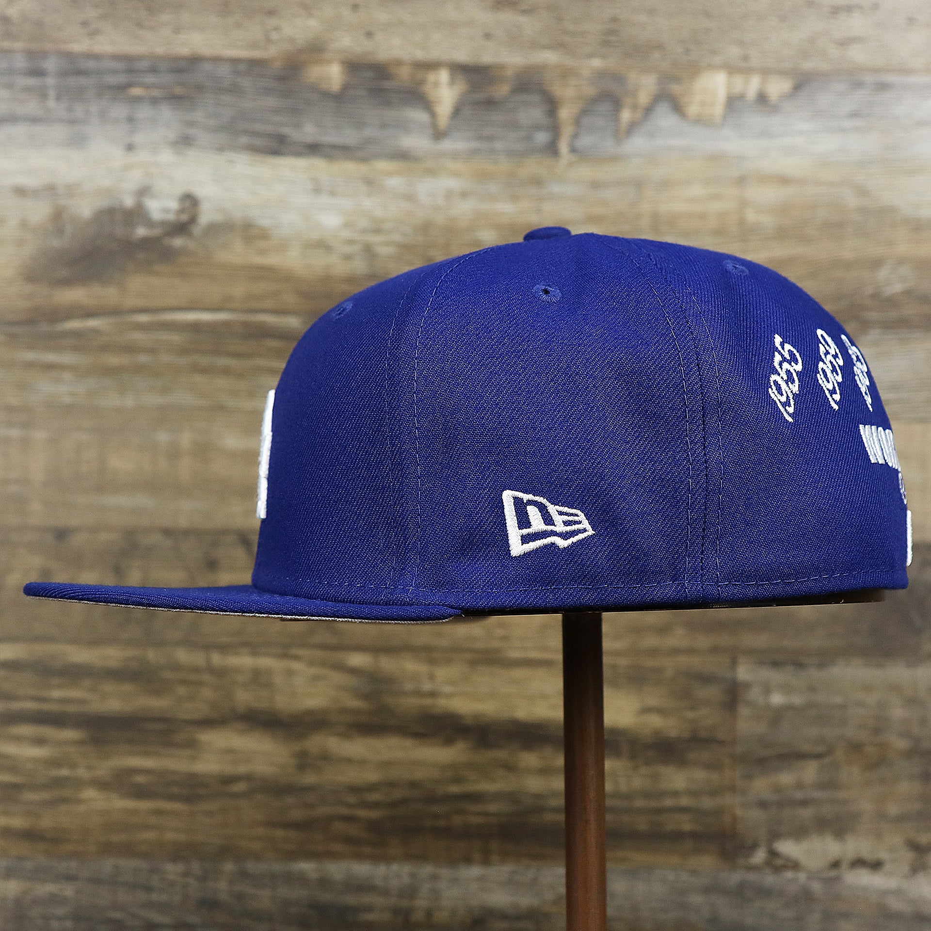 The wearer's left on the Los Angeles Dodgers Crown Champions Gray Bottom World Championship Wins Embroidered Fitted Cap | Royal Blue 59Fifty Cap