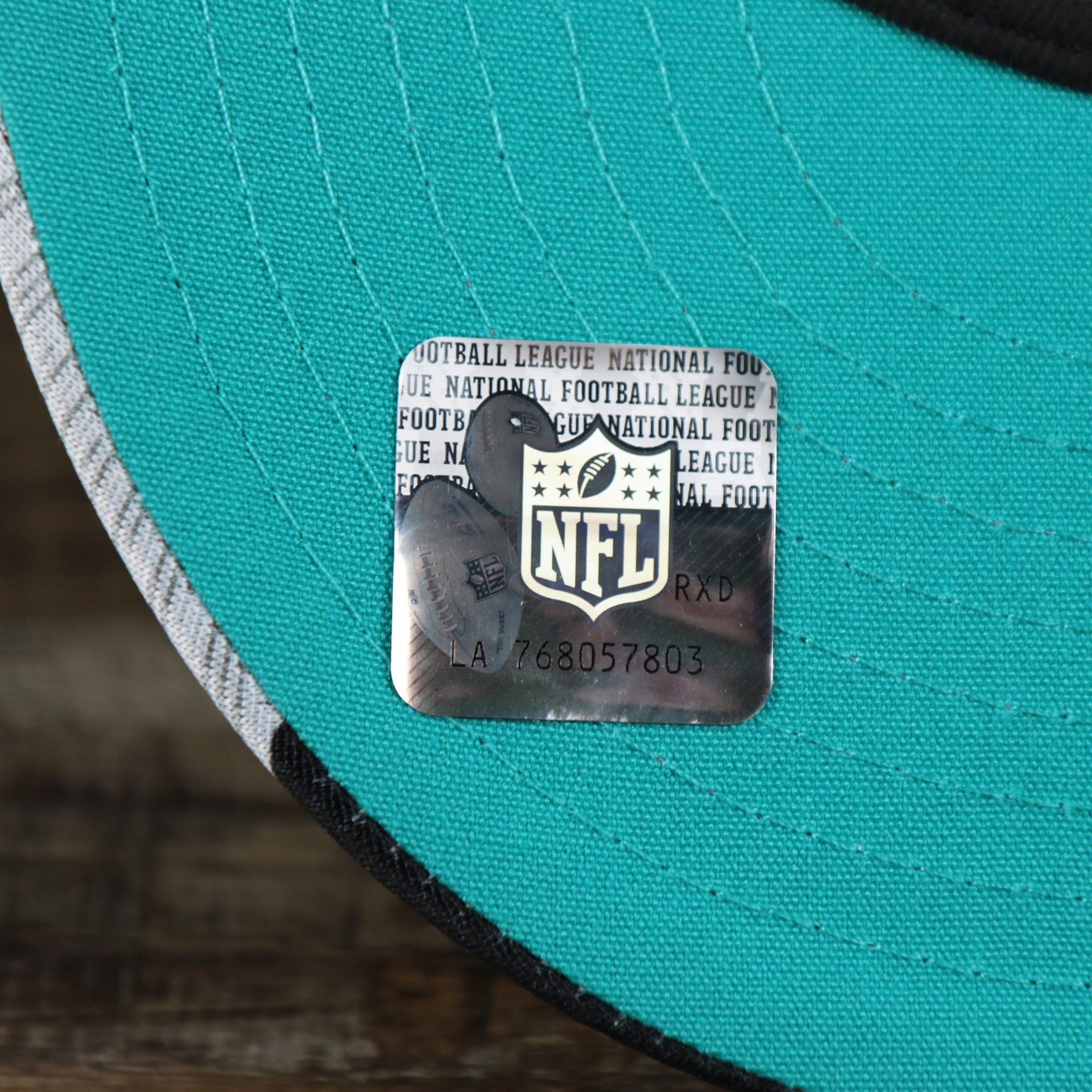 The NFL Sticker on the Miami Dolphins NFL OnField Summer Training 2022 Camo 9Fifty Snapback | Turquoise Camo 9Fifty