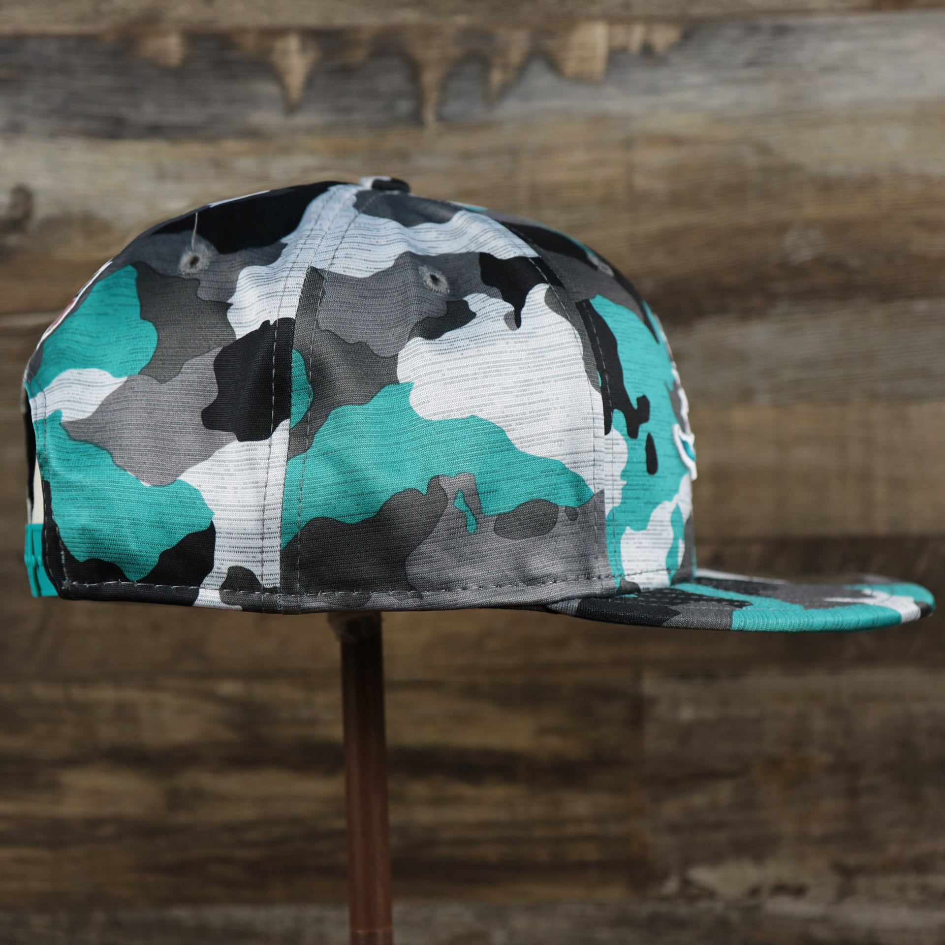 The wearer's right on the Miami Dolphins NFL OnField Summer Training 2022 Camo 9Fifty Snapback | Turquoise Camo 9Fifty
