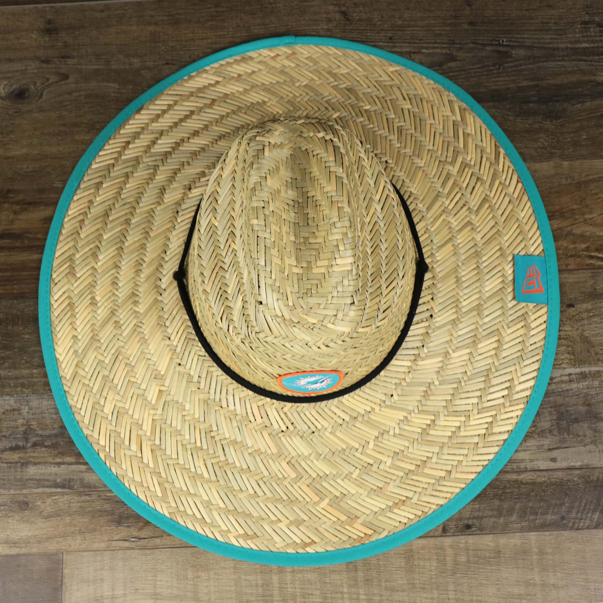 A overhead shot of the Miami Dolphins On Field 2022 Summer Training Straw Hat | New Era OSFM