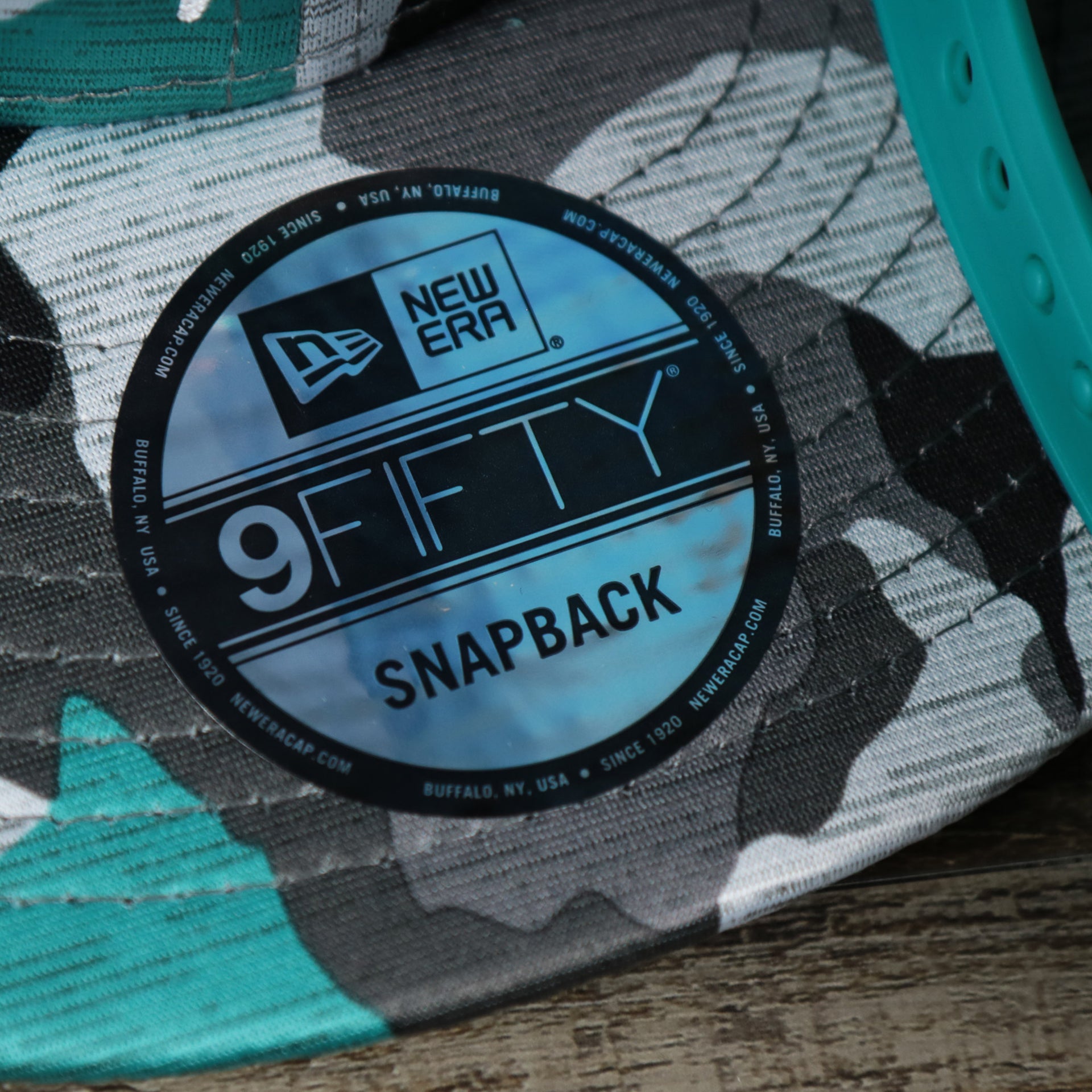The  9Fifty Sticker on the Miami Dolphins NFL OnField Summer Training 2022 Camo 9Fifty Snapback | Turquoise Camo 9Fifty