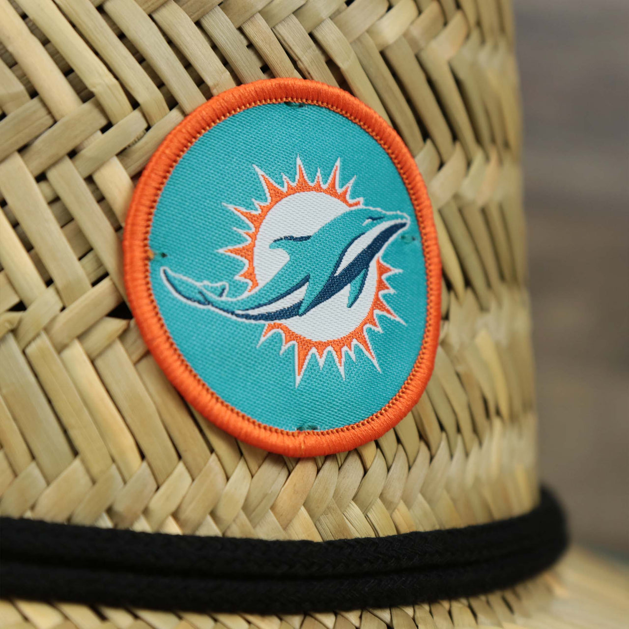 The Dolphins logo on the Miami Dolphins On Field 2022 Summer Training Straw Hat | New Era OSFM