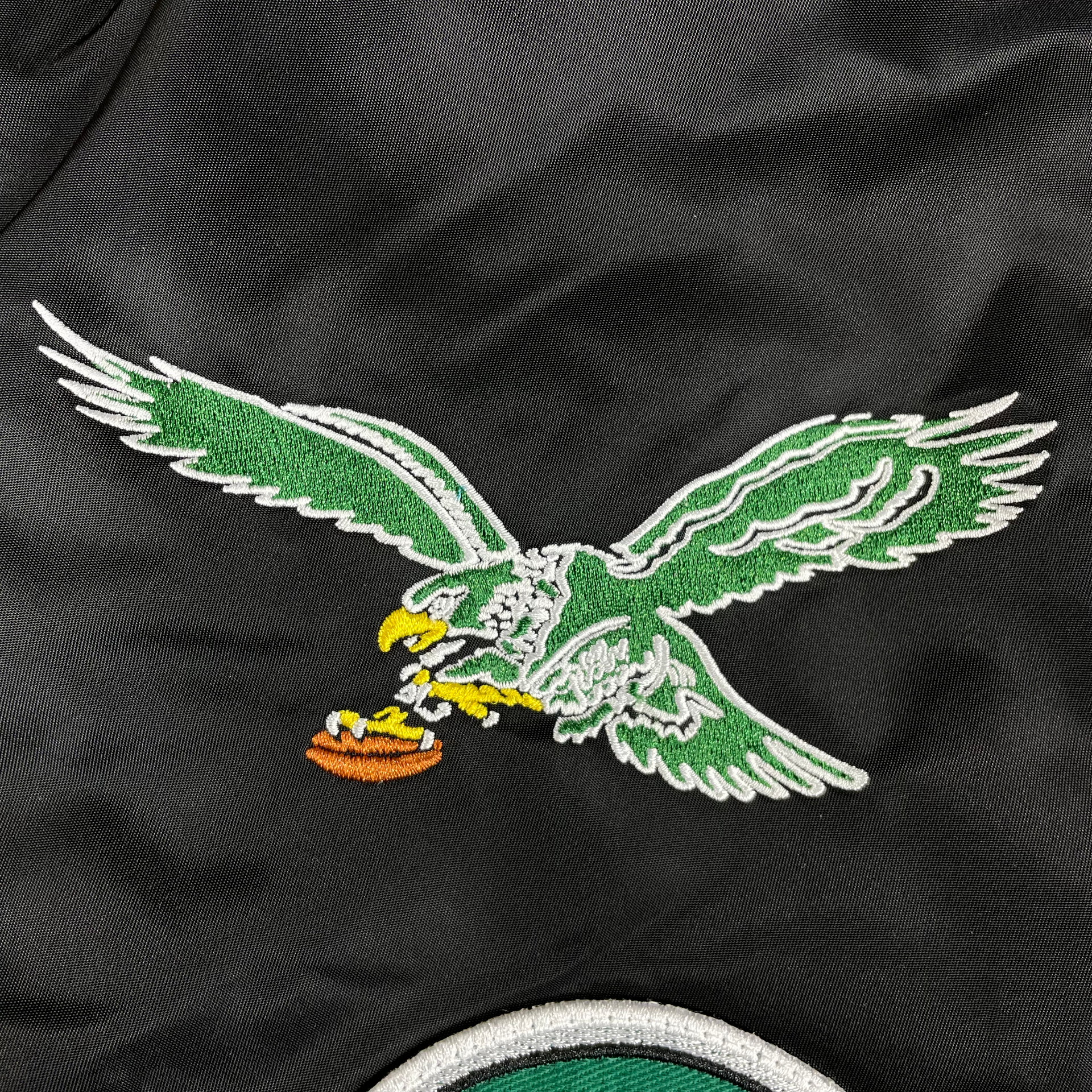 Close up of the Eagles throwback patch on the Philadelphia Eagles Throwback Men’s Vintage Reversible Bomber Jacket | Alpha Industries x New Era