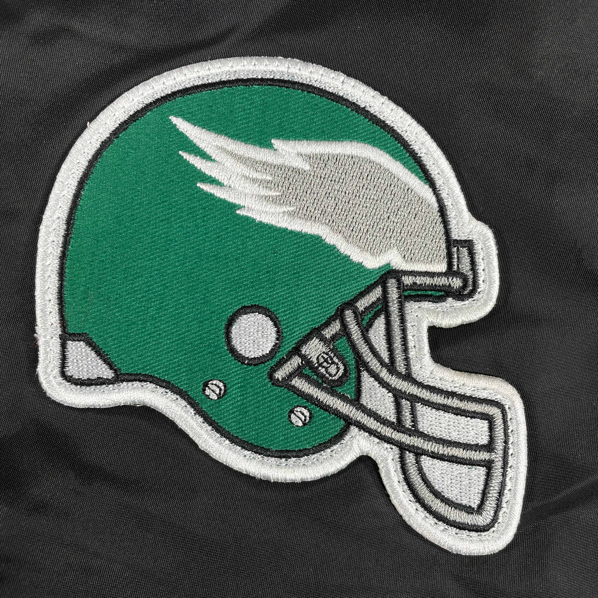 Close up of the throwback Eagles patch on the Philadelphia Eagles Throwback Men’s Vintage Reversible Bomber Jacket | Alpha Industries x New Era