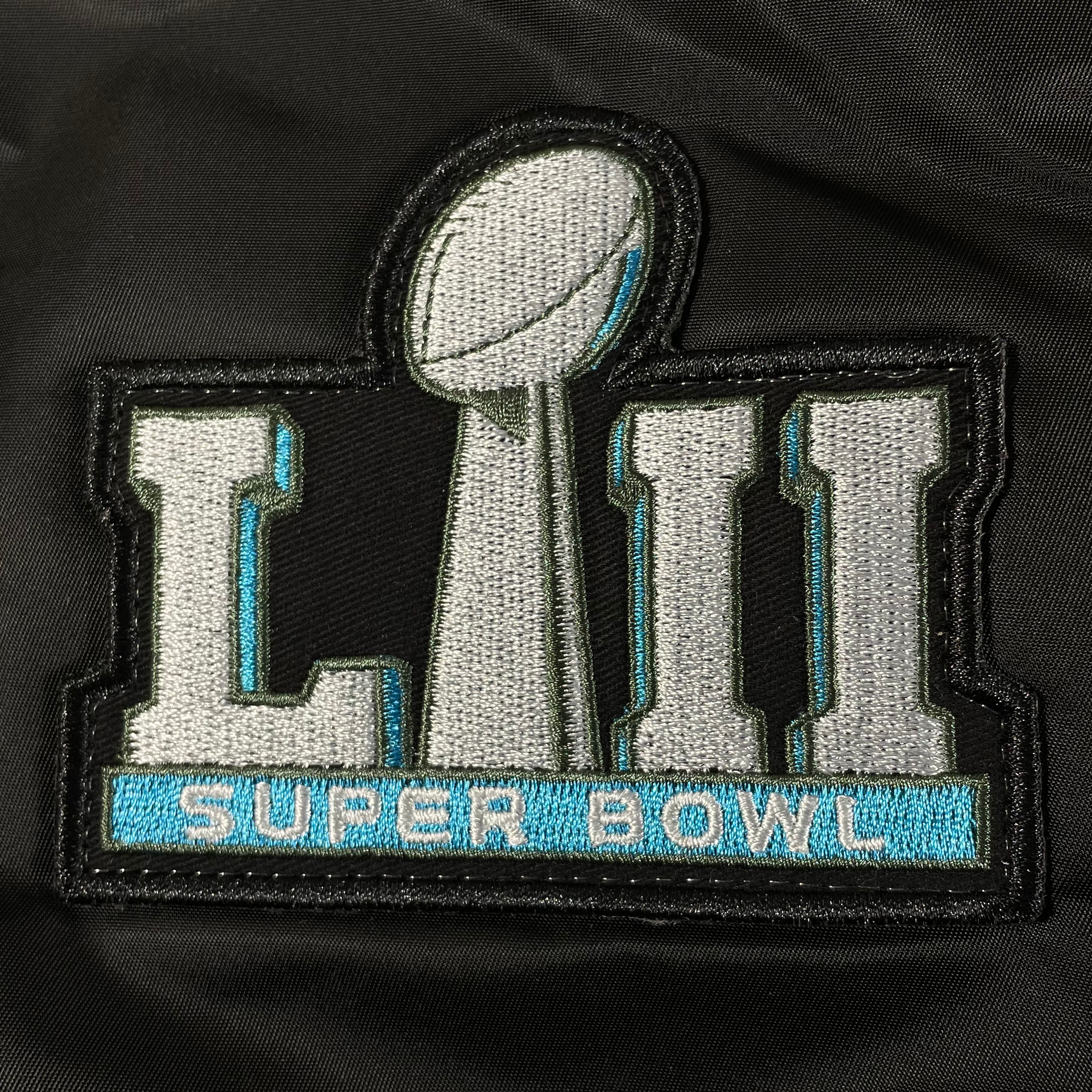 Close up of the Super Bowl 52 champion patch on the sleeve of the Philadelphia Eagles Throwback Men’s Vintage Reversible Bomber Jacket | Alpha Industries x New Era