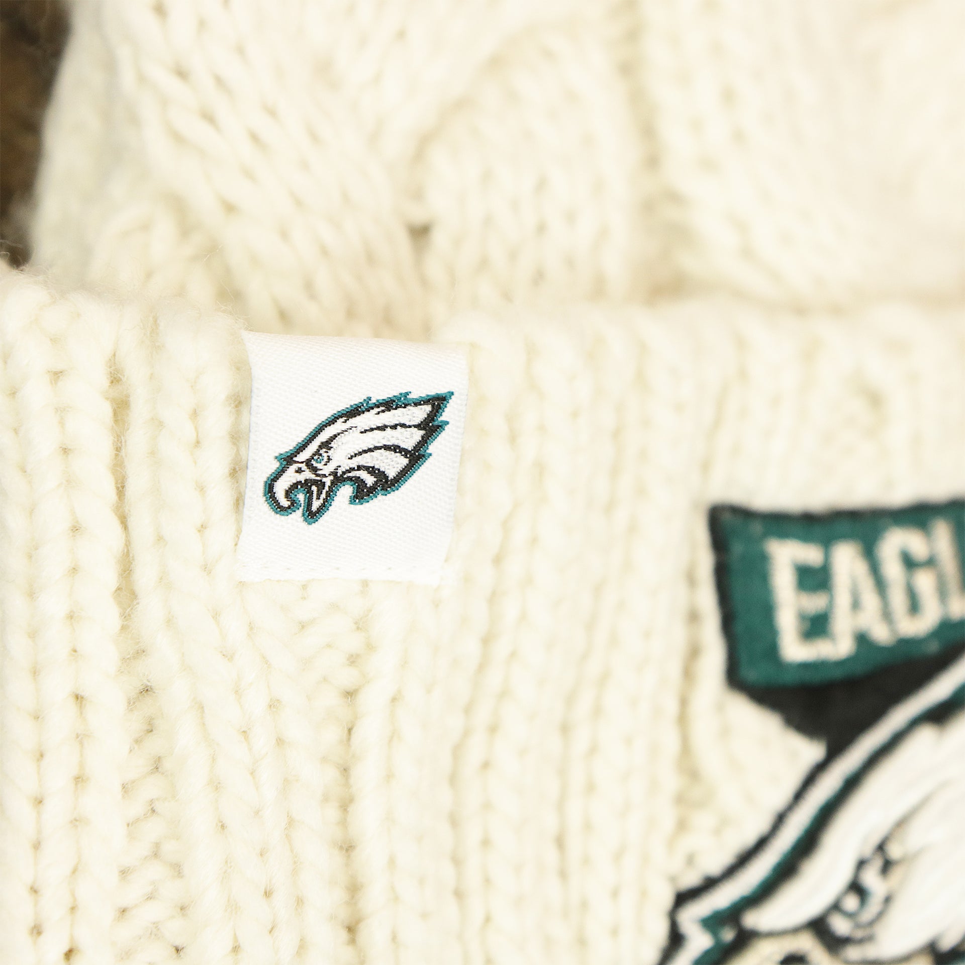The Eagles Tag on the Women’s Philadelphia Eagles 2022 NFC Cuffed Winter Knit Meeko Pom Pom Beanie | Women’s White Winter Beanies