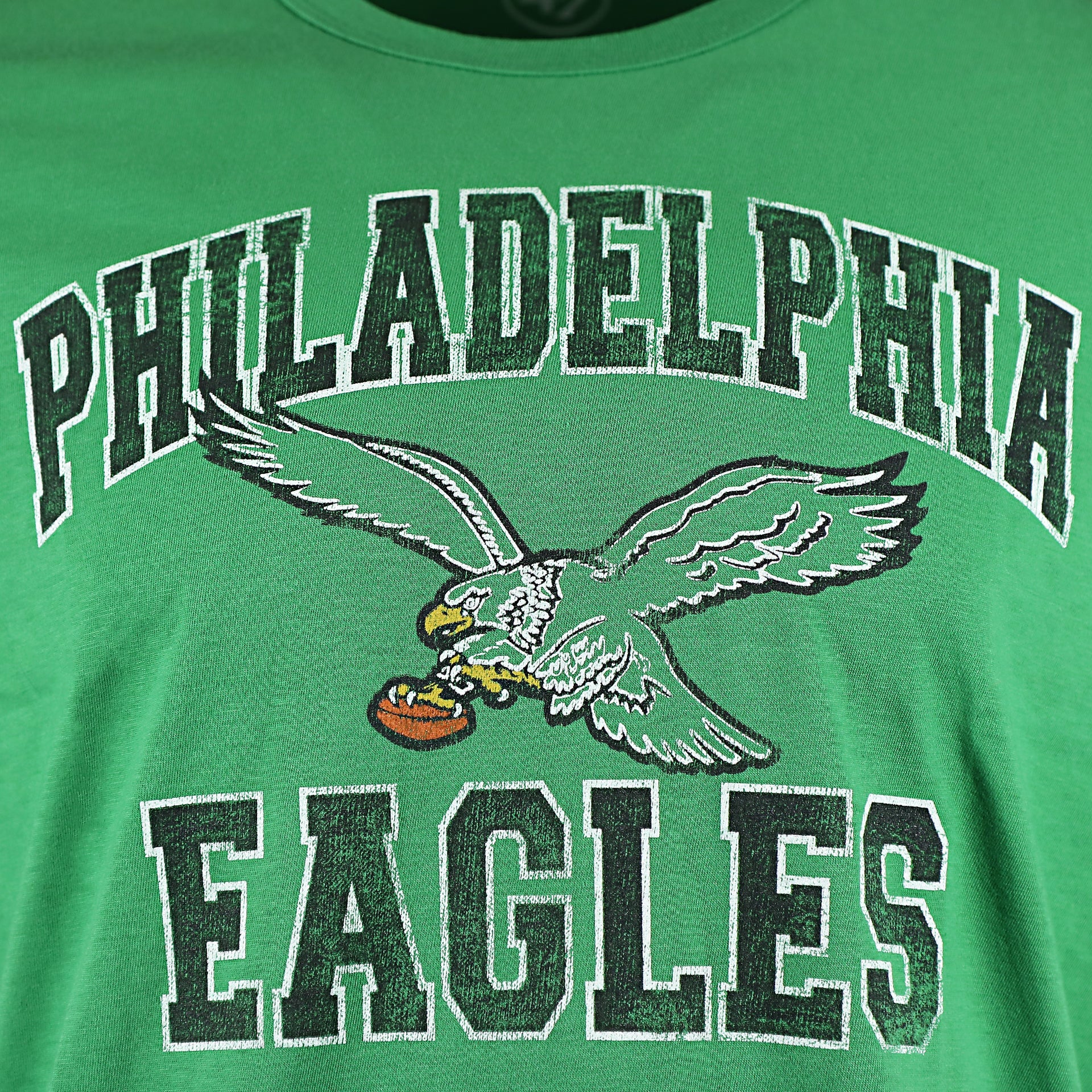Close up of the distressed Eagles wordmark print on the front of the Philadelphia Eagles Throwback Logo Arch Wordmark Premium Franklin Kelly Green T-Shirt