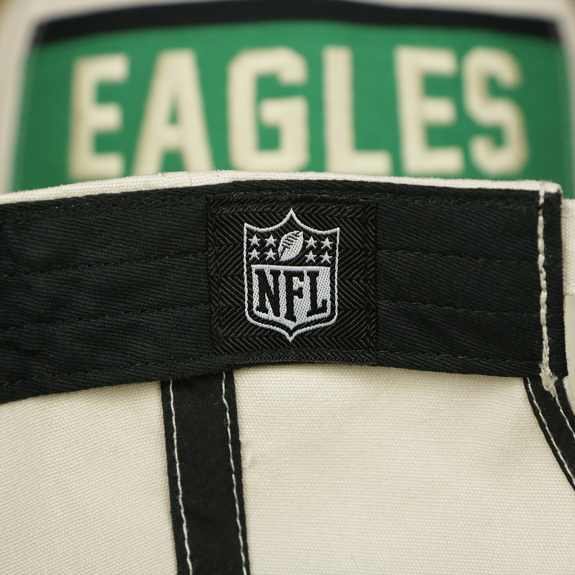 The NFL Tag on the Throwback Philadelphia Eagles Striped Wordmark Legacy Eagles Side Patch Crossroad Dad Hat | Bone Dad Hat