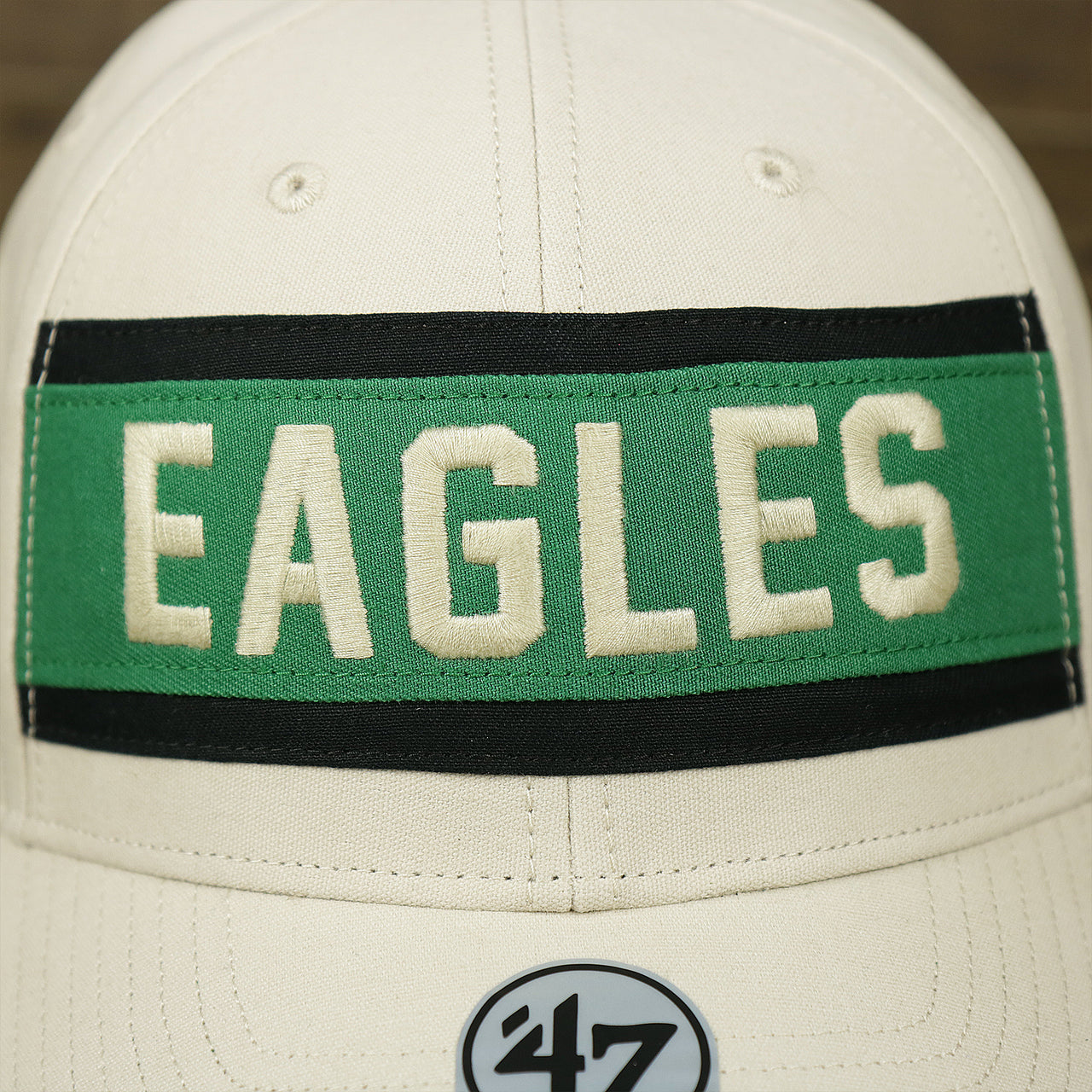 The Eagles Wordmark on the Throwback Philadelphia Eagles Striped Wordmark Legacy Eagles Side Patch Crossroad Dad Hat | Bone Dad Hat