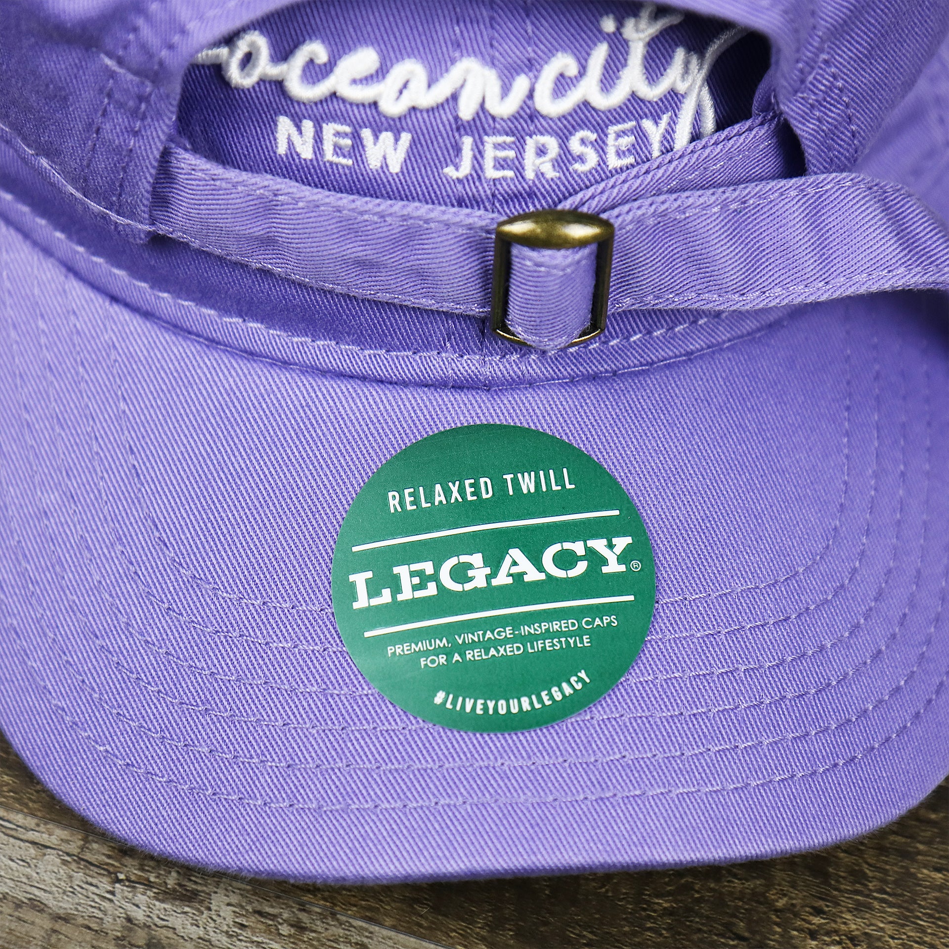 The Legacy Sticker on the Ocean City New Jersey Cursive Wordmark Dad Hat | Lavender Dad Hat