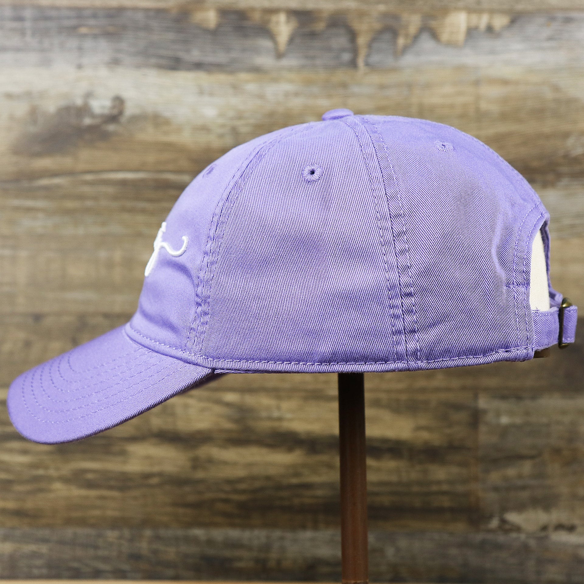 The wearer's left on the Ocean City New Jersey Cursive Wordmark Dad Hat | Lavender Dad Hat