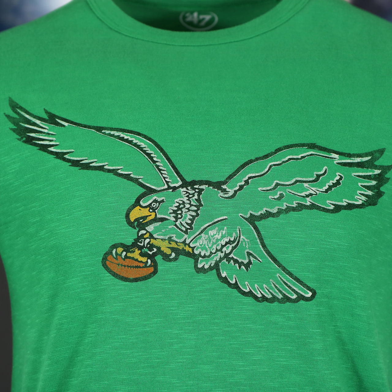 logo on the front of the Philadelphia Eagles Distressed Throwback Kelly Green Bird Logo Kelly Green Legacy Grit T-Shirt