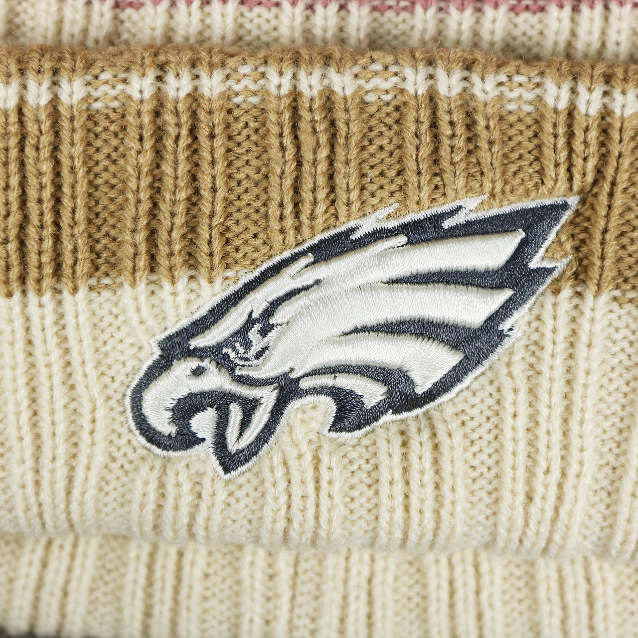 The Eagles Logo on the Women’s Philadelphia Eagles Black And White Eagles Logo Pom Pom Beanie | Women’s Natural Beanie