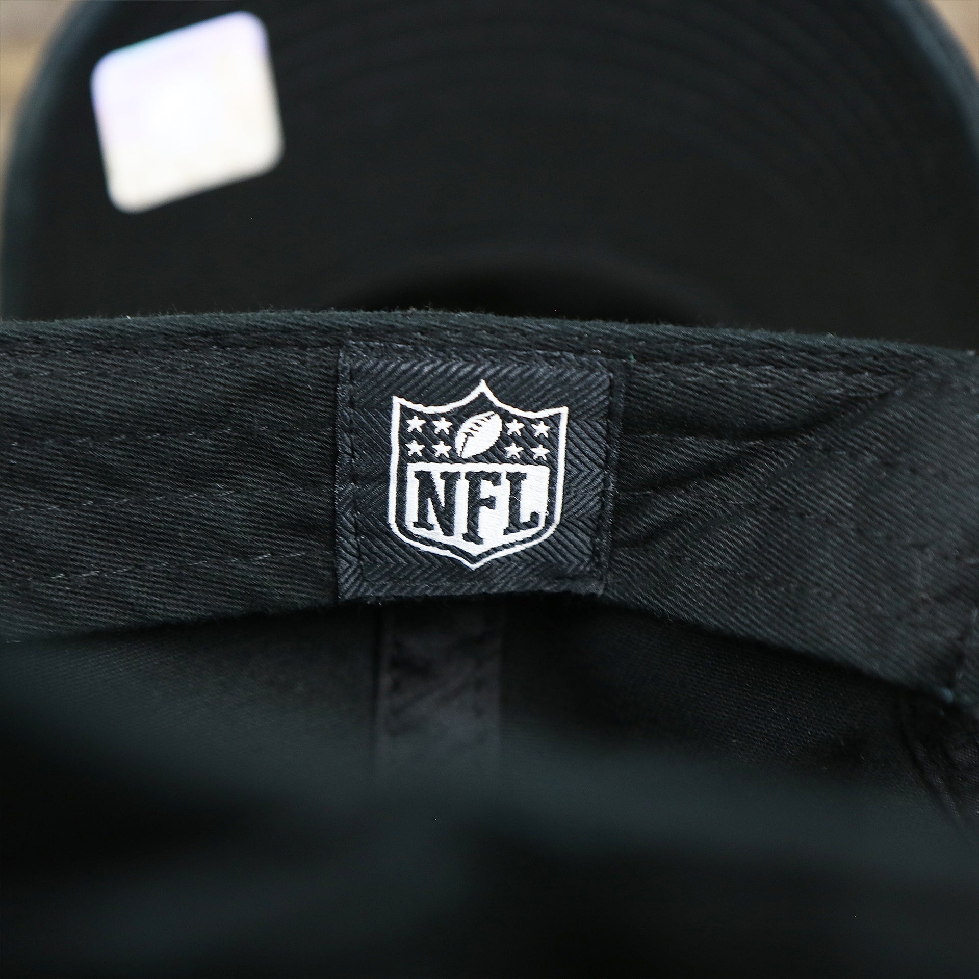 The NFL Tag on the Philadelphia Eagles Logo Adjustable Dad Hat | Black Dad Hat