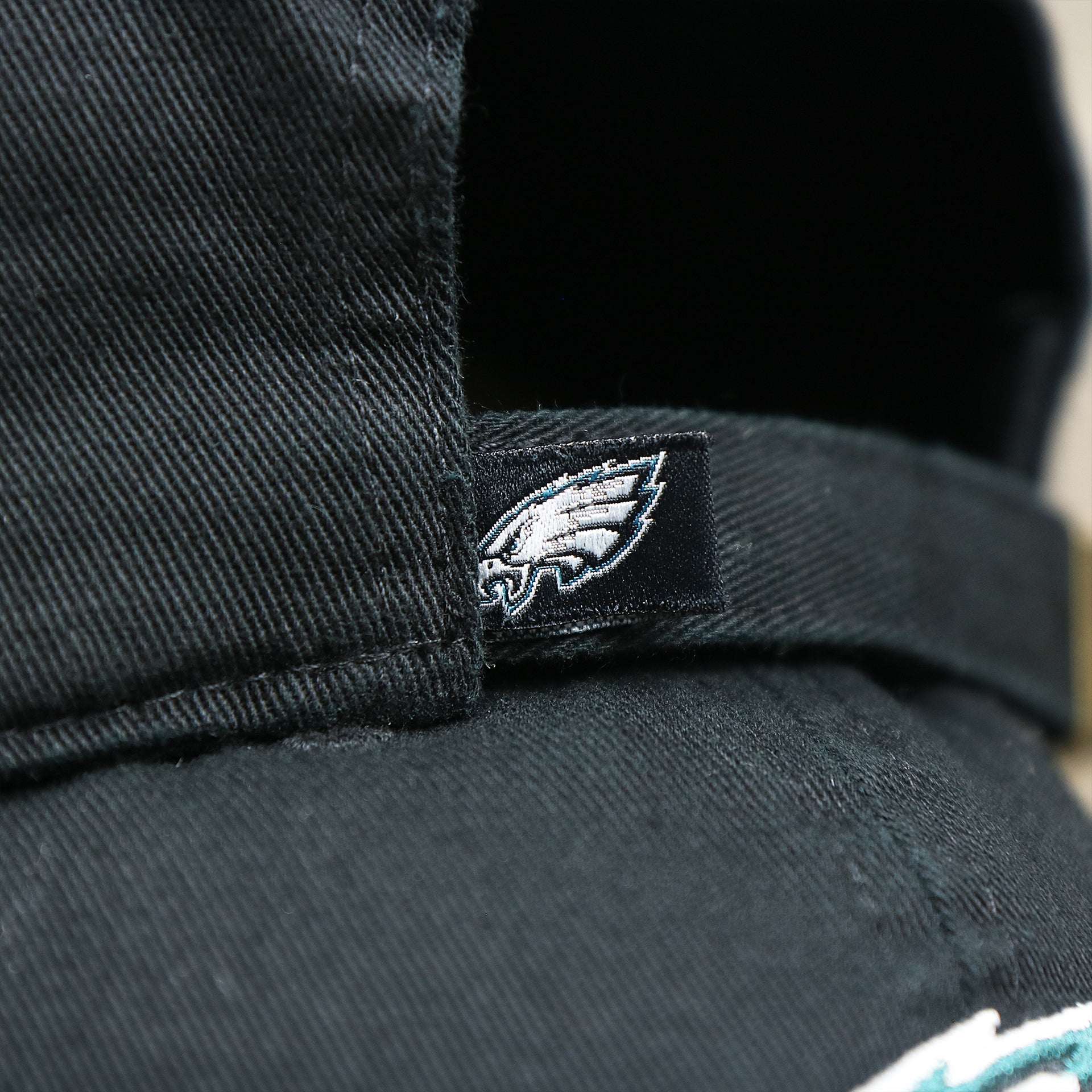 The Eagles Tag on the Philadelphia Eagles Logo Adjustable Dad Hat | Black Dad Hat