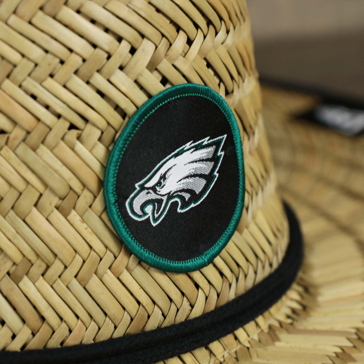 The Eagles logo on the Philadelphia Eagles On Field 2022 Summer Training Straw Hat | New Era OSFM