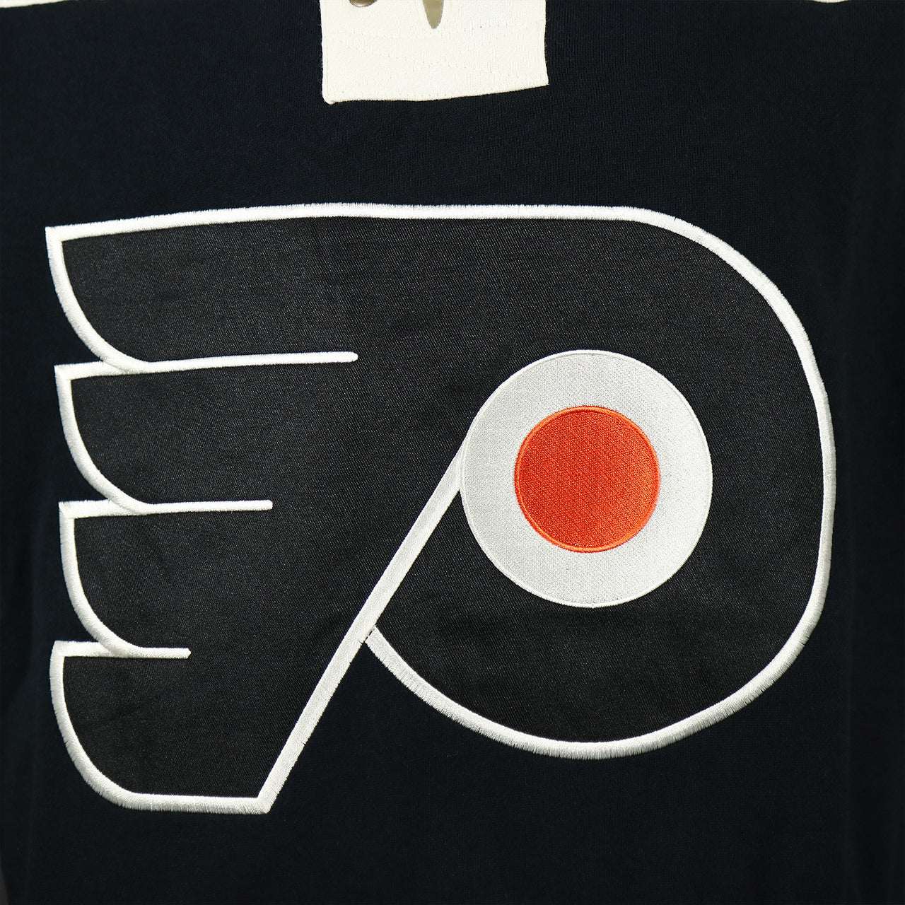 Close up of the Flyers logo on the front of the Philadelphia Flyers Premium Applique Black/Orange/Cream Lacer Hoodie