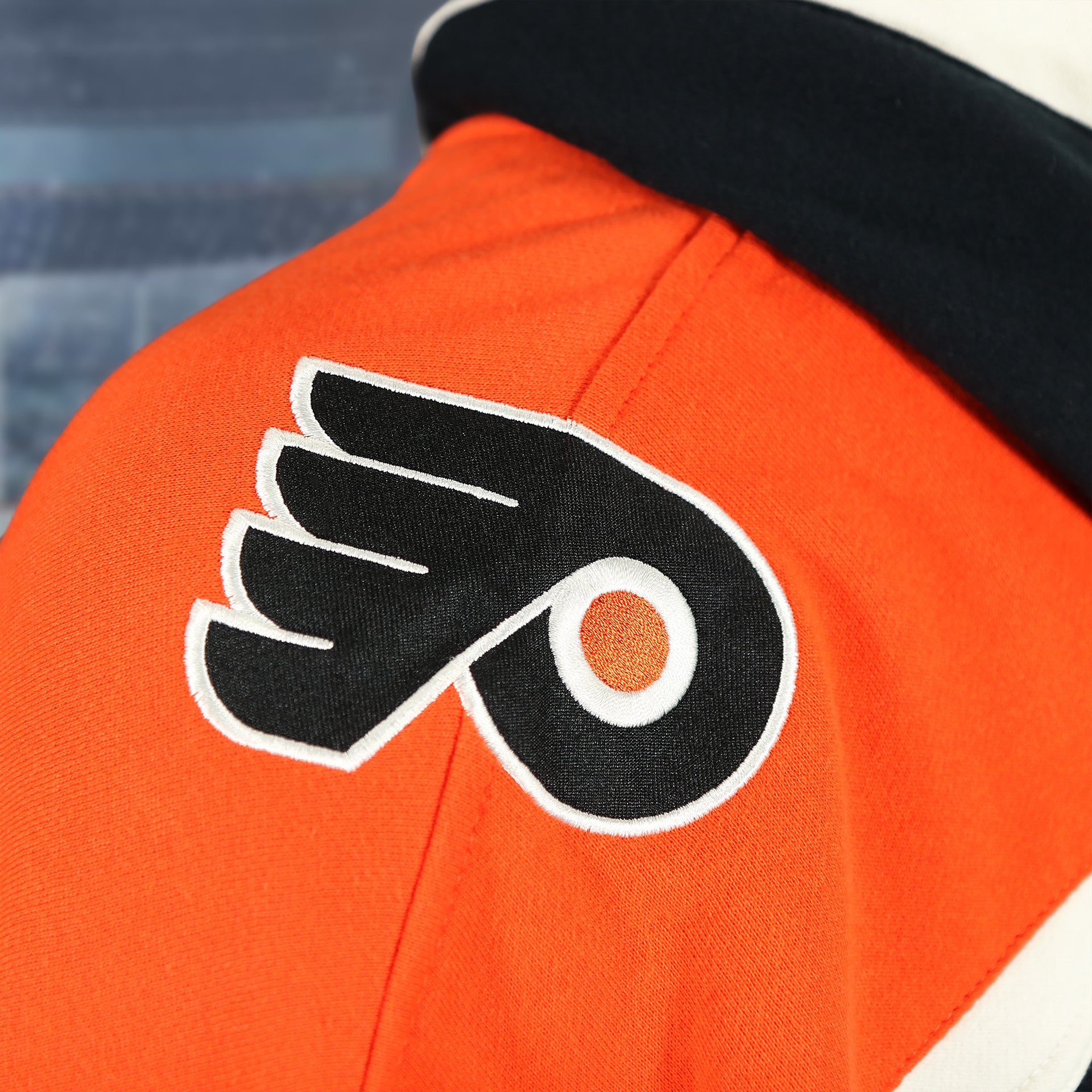 Close up of the shoulder Flyers logo patch on the Philadelphia Flyers Premium Applique Black/Orange/Cream Lacer Hoodie