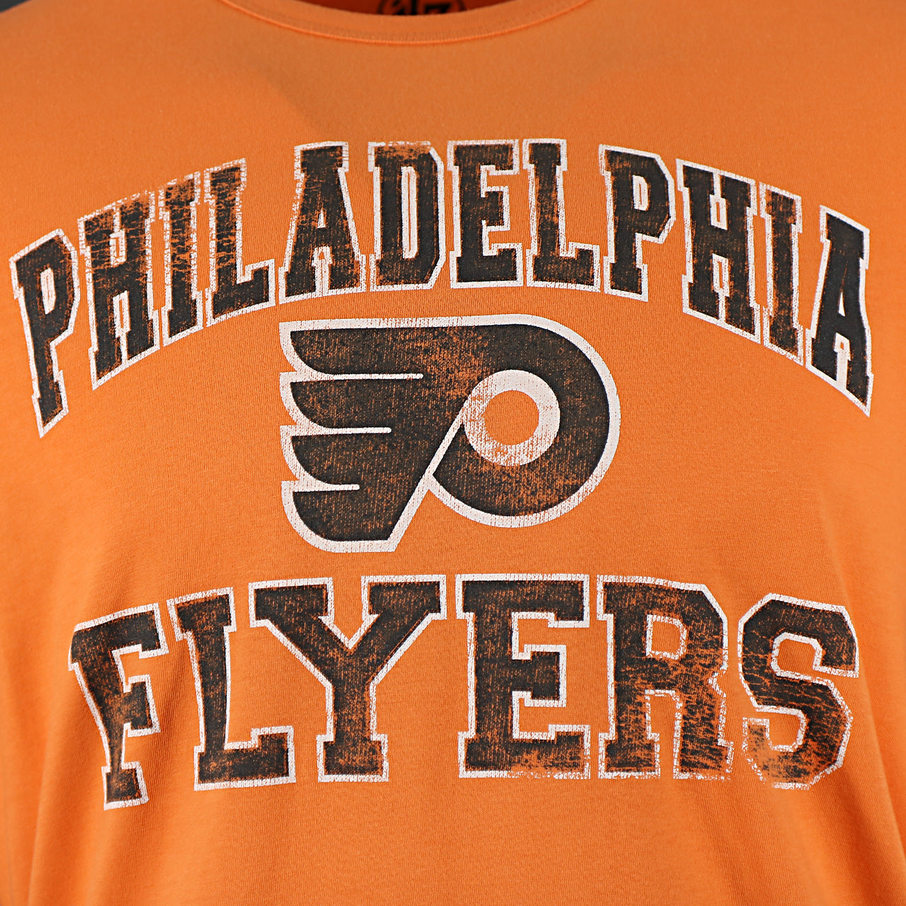 Close up of the front logo on the Philadelphia Flyers Distressed Arch Wordmark Premium Franklin T-Shirt