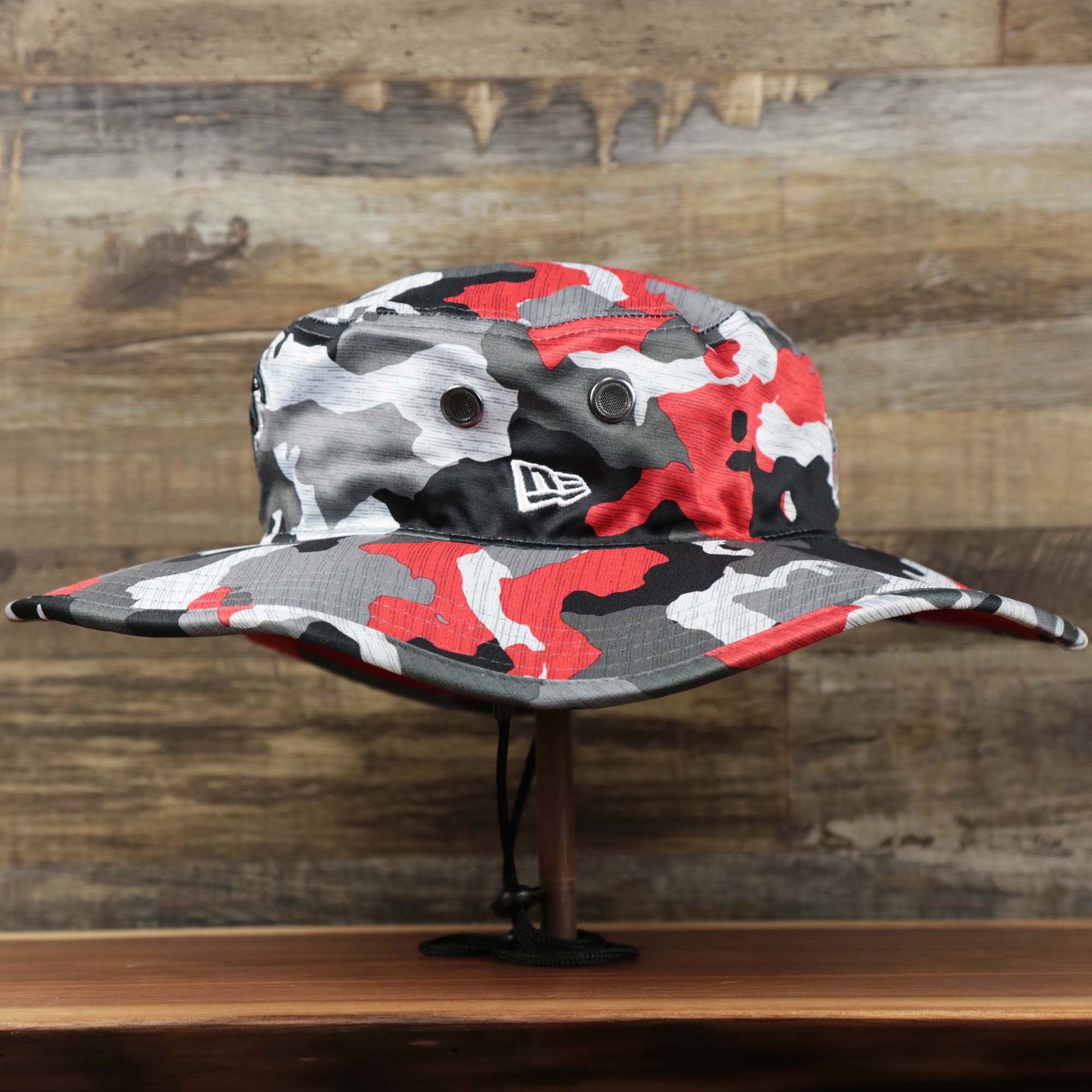 The wearer's left on the Atlanta Falcons NFL Summer Training Camp 2022 Camo Bucket Hat | Red Bucket Hat