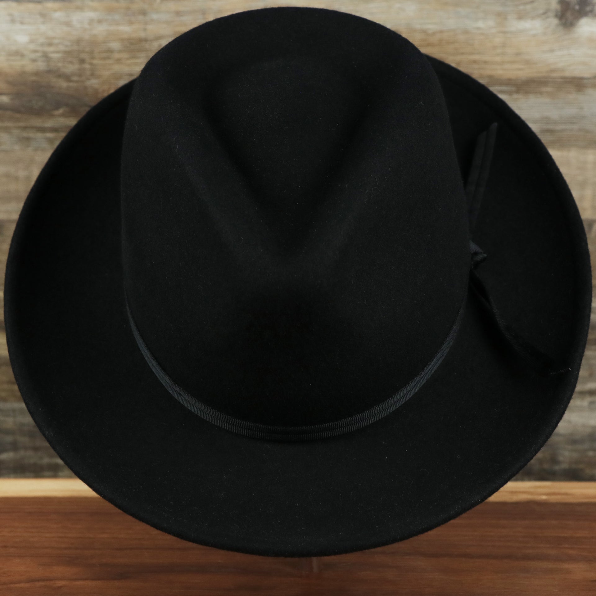 an overhead view of the Small Brim Folded Edge Black Fedora Hat with Black Wool Interior | Jack and Arrow 100% Australian Wool