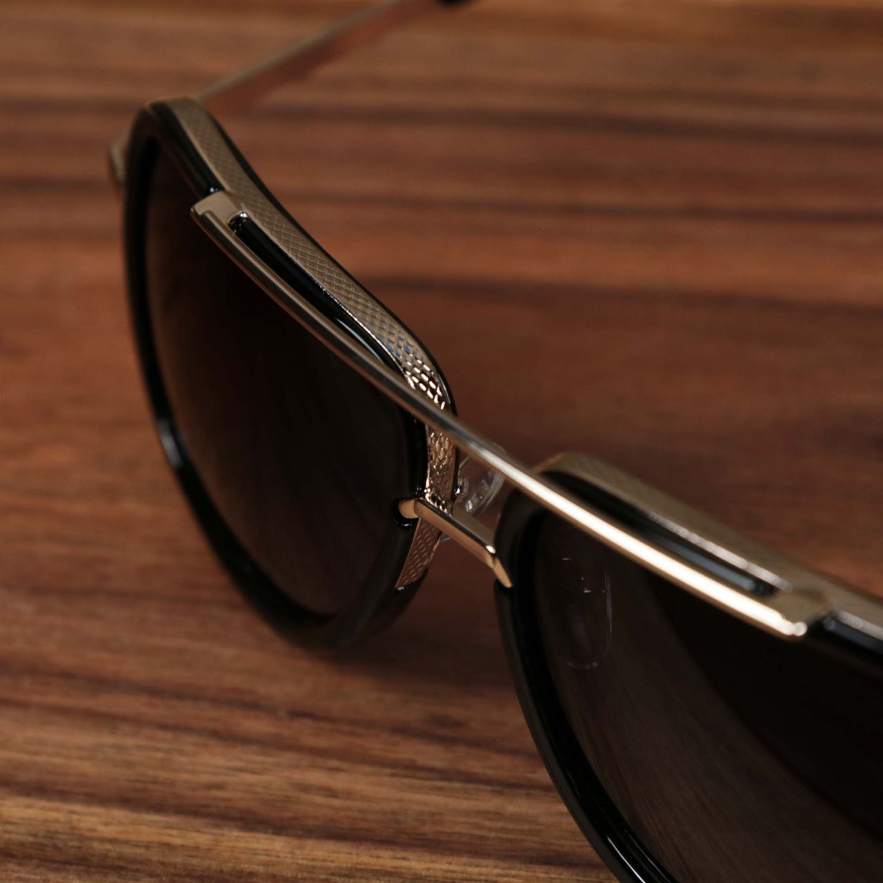 The bridge on the Round Frames Black Lens Sunglasses with Black Gold Frame