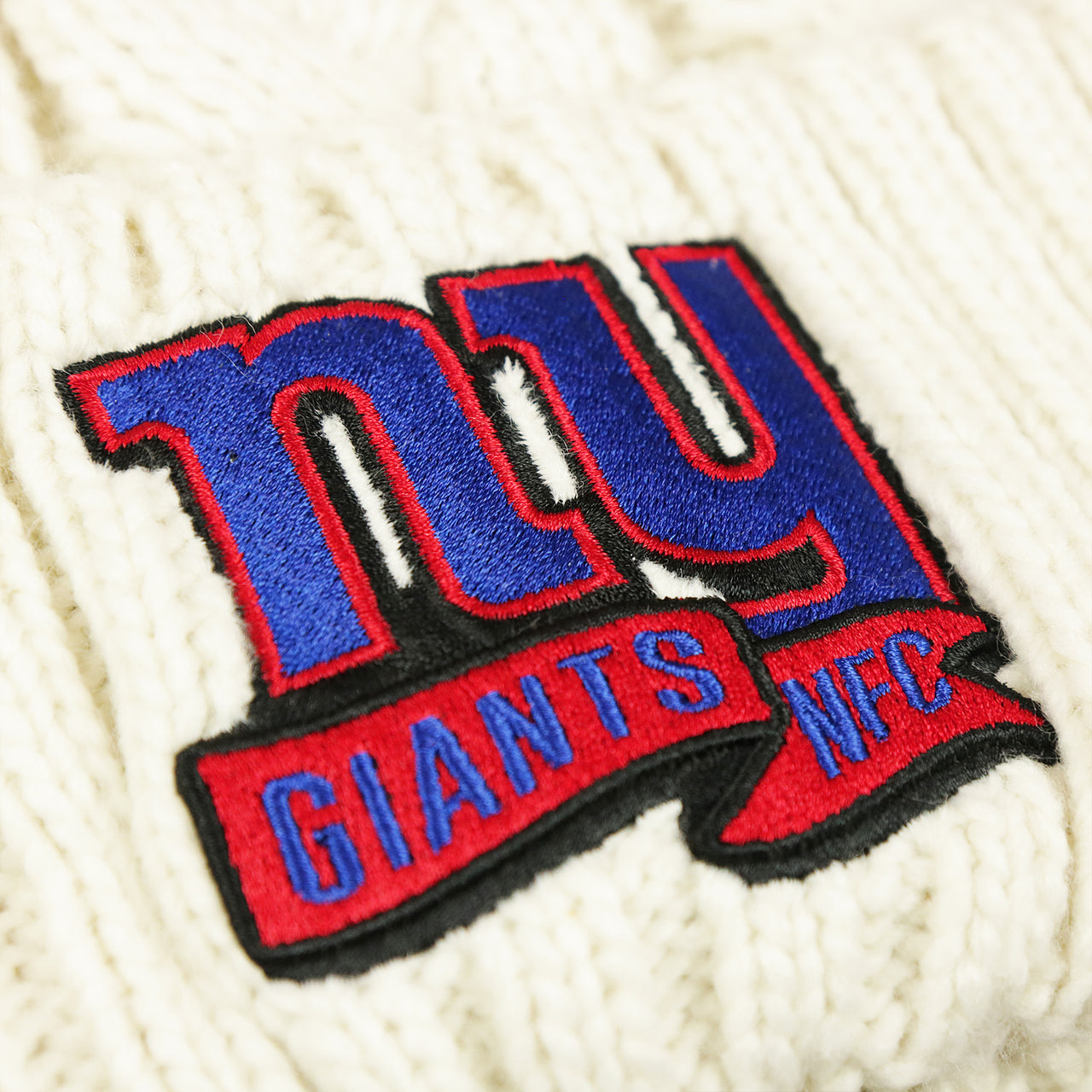 The Giants NFC Banner on the Women’s New York Giants 2022 NFC Cuffed Winter Knit Meeko Pom Pom Beanie | Women’s White Winter Beanies