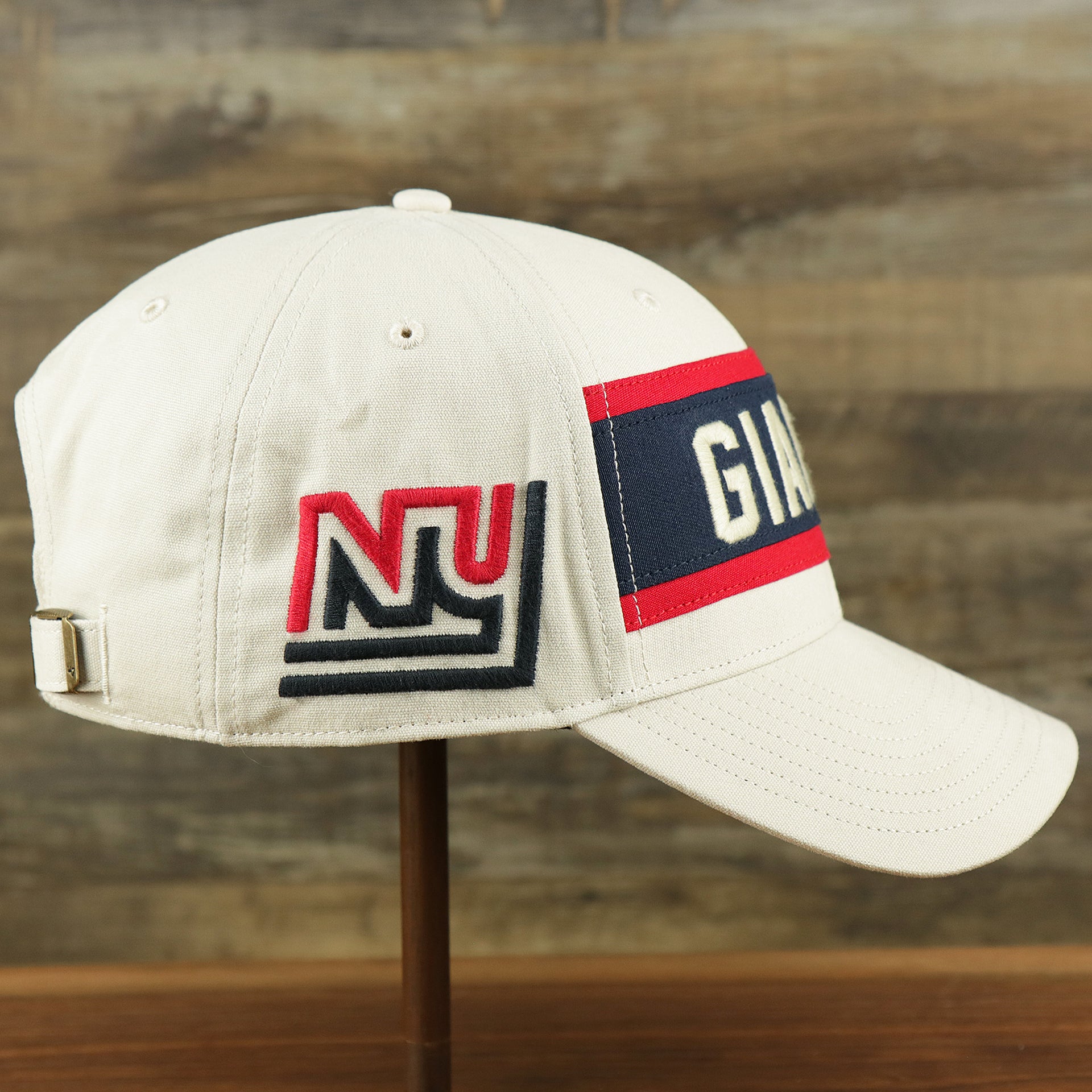 The wearer's right on the Throwback New York Giants Striped Wordmark Legacy Giants Side Patch Crossroad Dad Hat | Bone Dad Hat