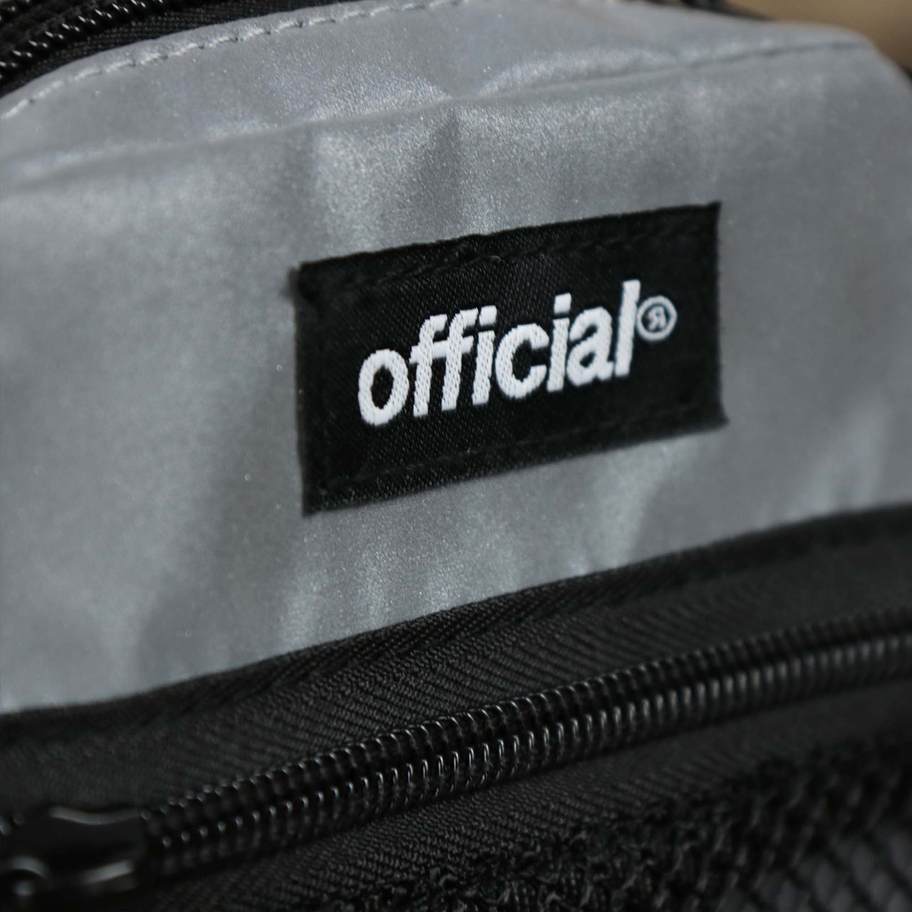 The official tag on the Reflective 3M Essential Nylon Shoulder Bag Streetwear | Official Reflective Silver