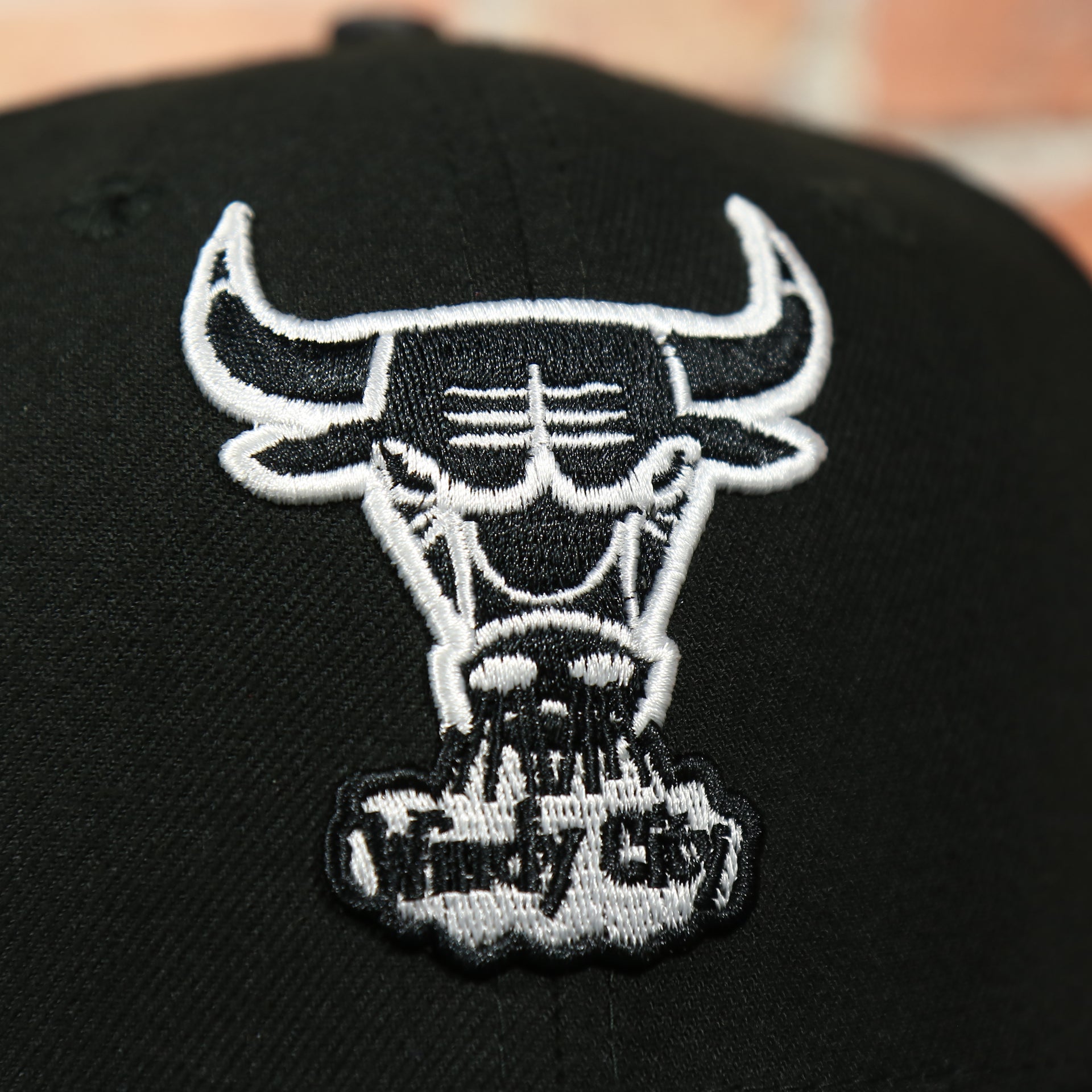 bulls logo on the front of the Chicago Bulls Black 59FIFTY Grey Bottom Fitted Cap | Black