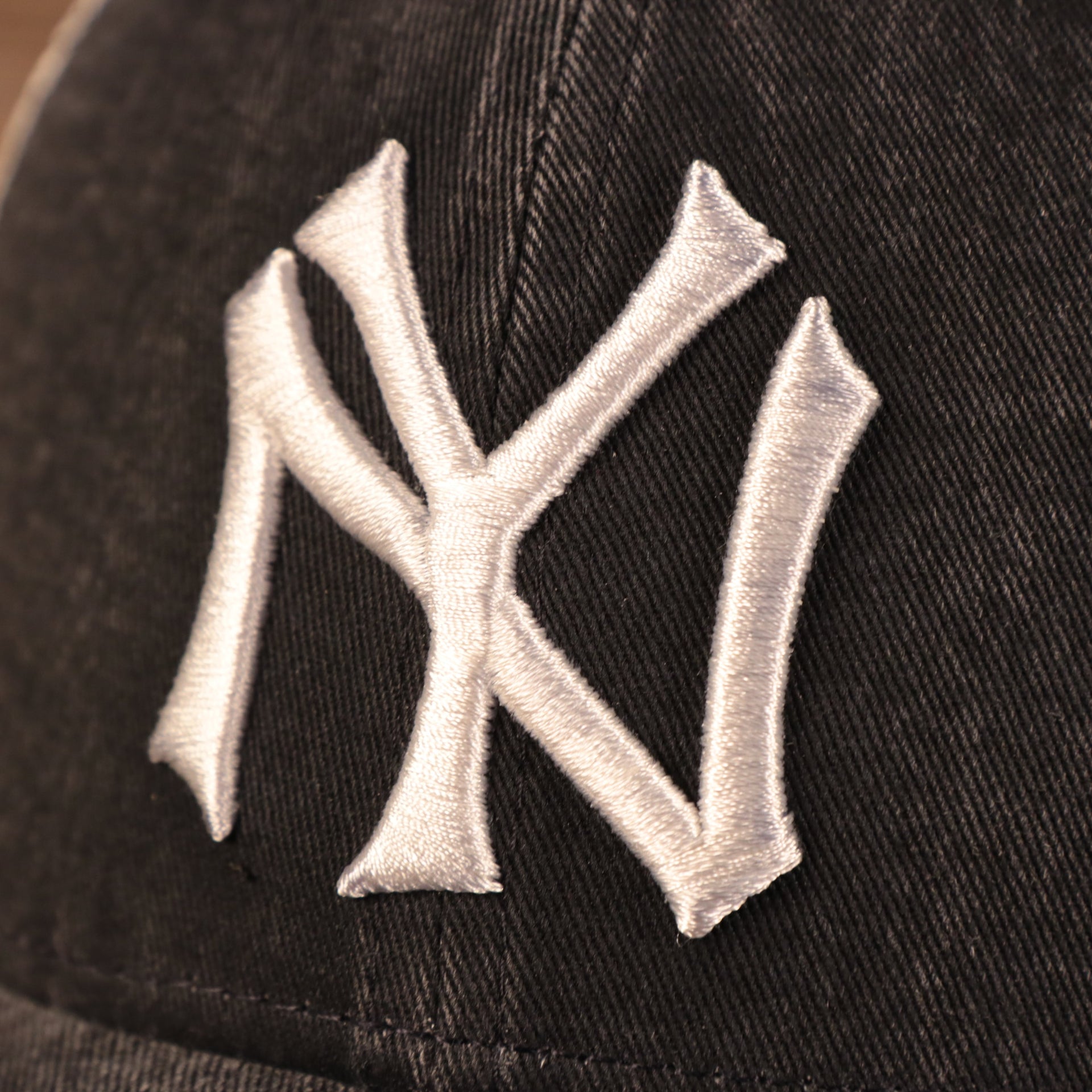 yankees logo on the New York Yankees Vintage Dark Gray Adjustable 9Forty Trucker Dad Hat