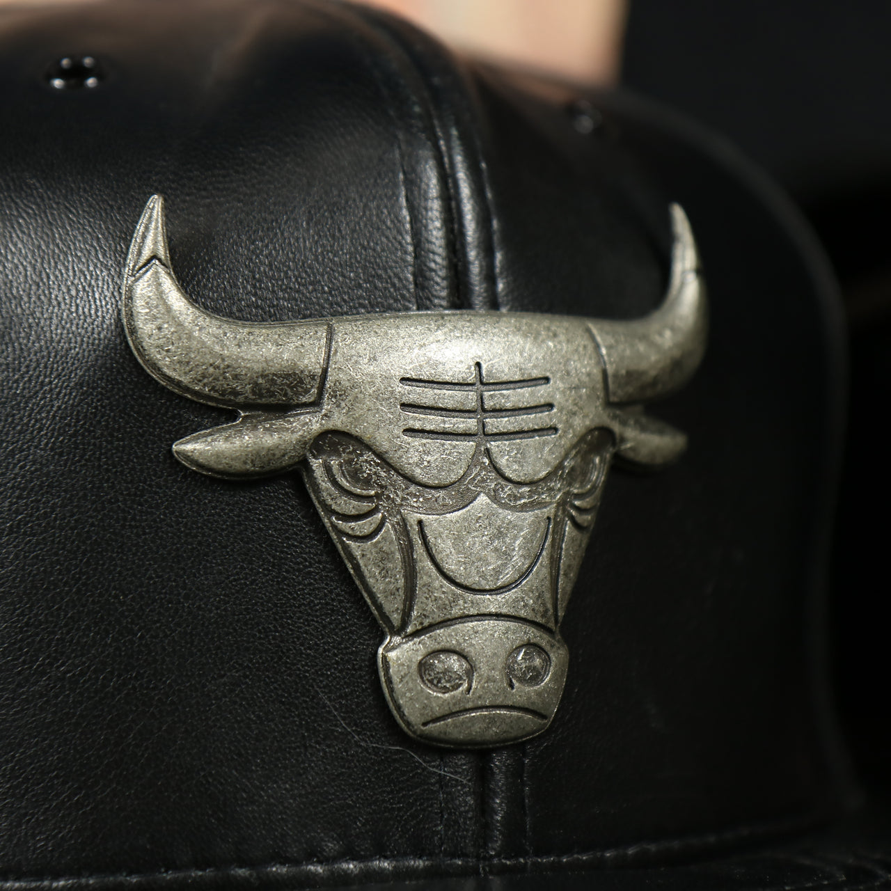 bulls logo on the Chicago Bulls 100% Genuine Lambskin Leather Metallic Embossed Bull Logo Mitchell and Ness Black Snapback Hat
