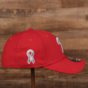 The light blue ribbon patch on the wearer's right side of the Phillies red fathers day 2021 39thirty flexfit cap by New Era.