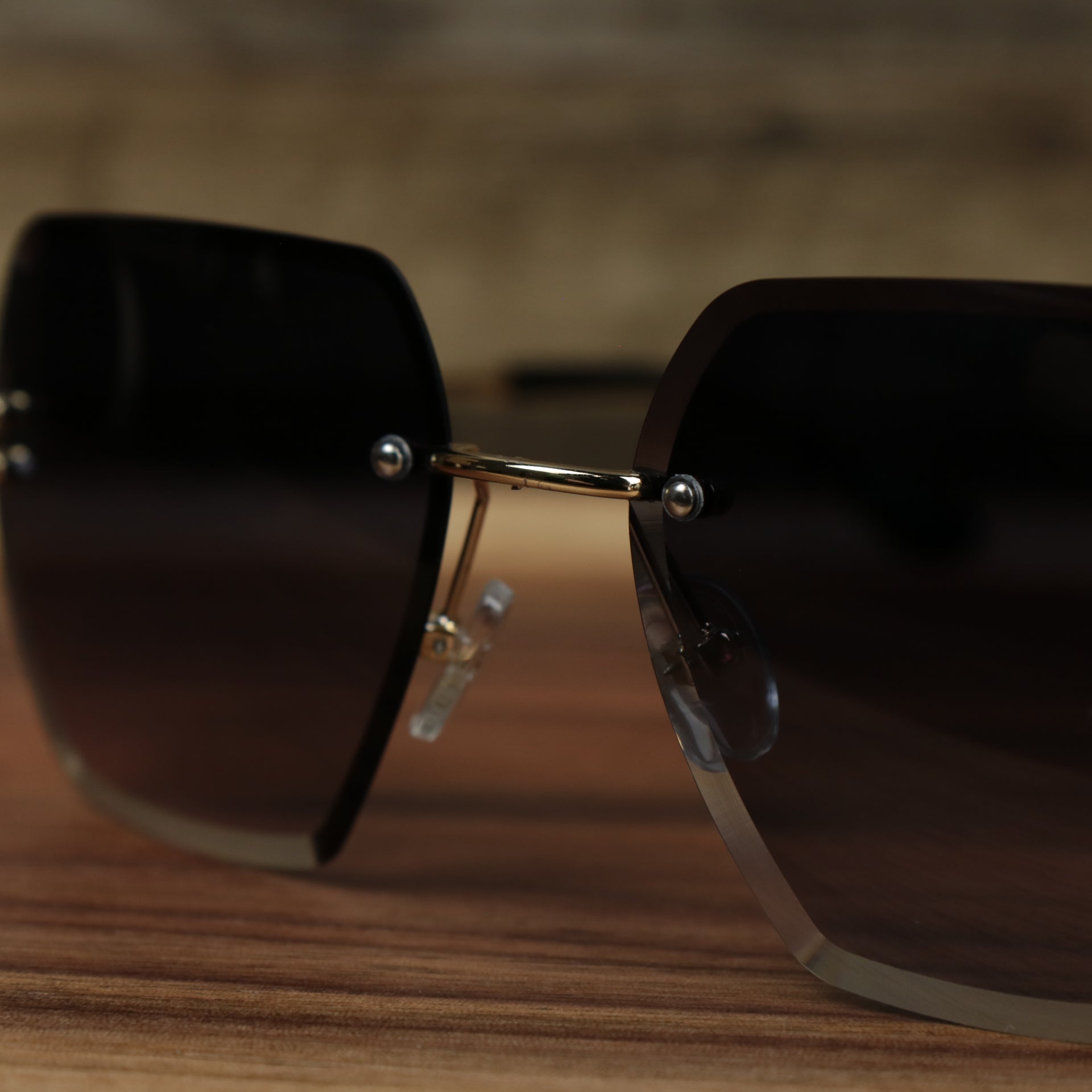 A close up of the bridge on the Large Lightweight Frame Black Lens Sunglasses with Gold Frame