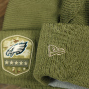 The New Era Logo on the Philadelphia Eagles Salute To Service Ribbon Rubber Military Eagles Patch On Field NFL Beanie | Military Green Beanie