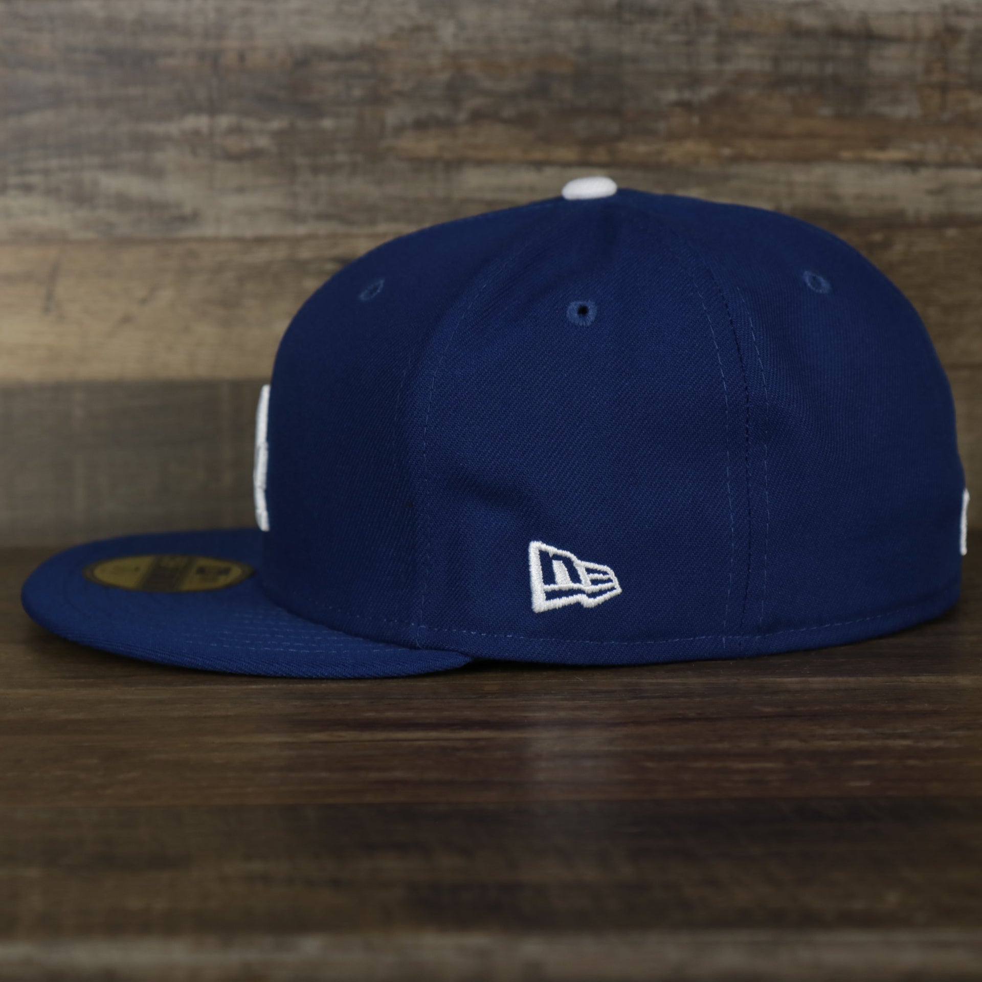 The wearer's right on the Los Angeles Dodgers Jackie Robinson Side Patch 59Fifty Black Bottom Fitted Cap